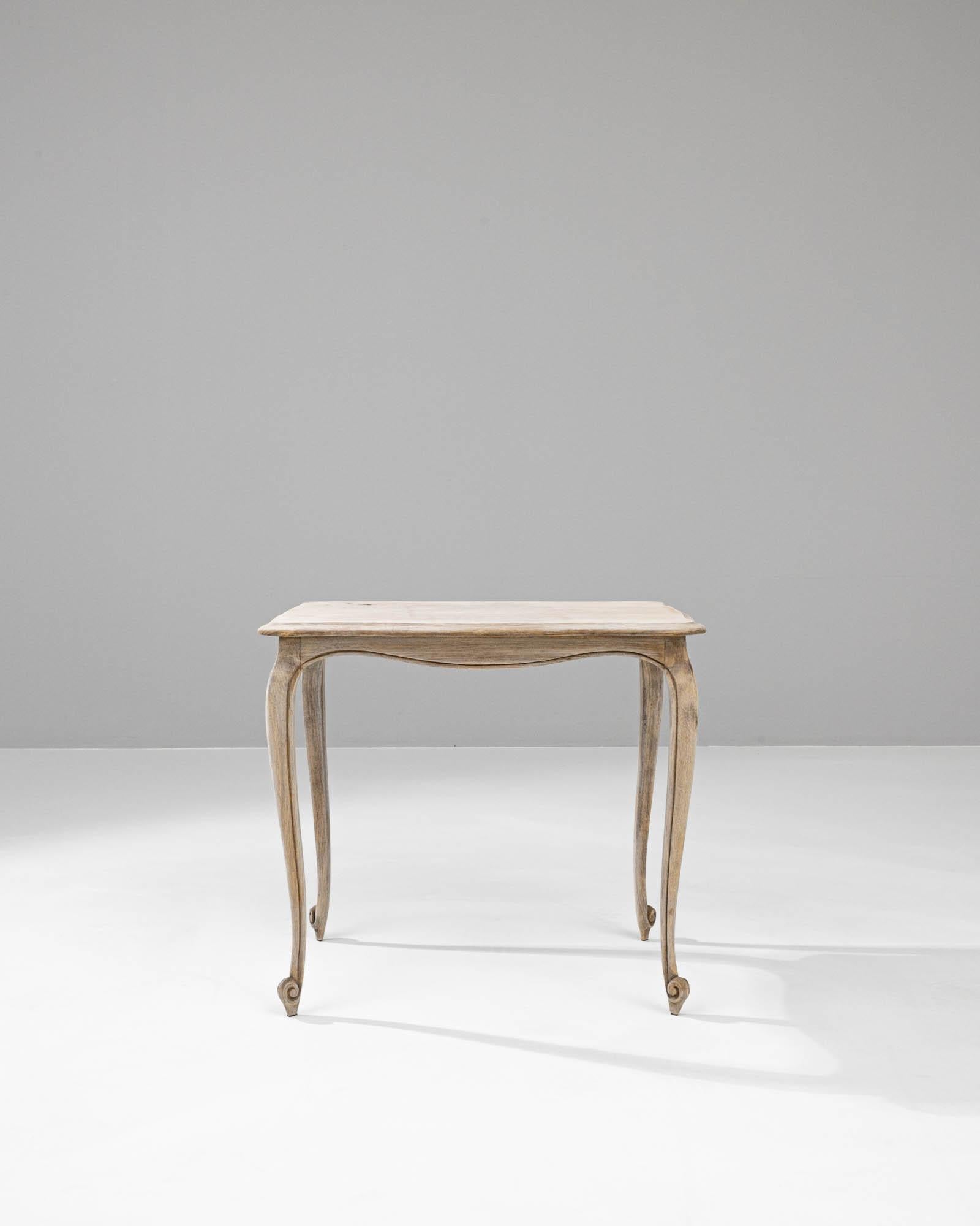 This 20th Century Belgian Bleached Oak Side Table beautifully captures the essence of rustic elegance. Crafted from solid oak, its wood grain is highlighted by a gentle bleaching process that offers a soft, weathered patina, evoking a sense of
