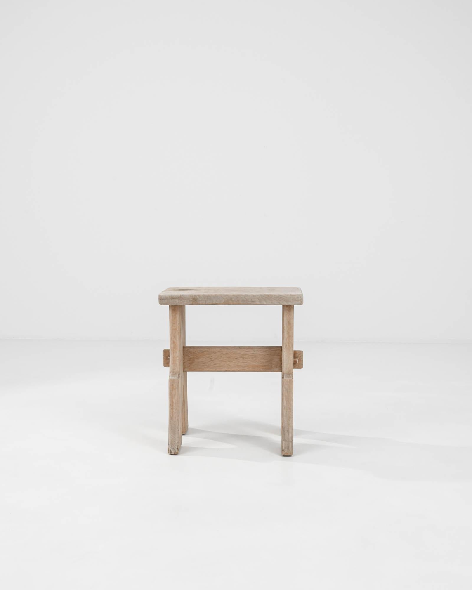 Experience the understated elegance of our 20th Century Belgian Bleached Oak Stool. Meticulously restored to showcase its original beauty, this simple yet refined piece exudes a timeless appeal. The bleached oak finish infuses a soft, natural hue,