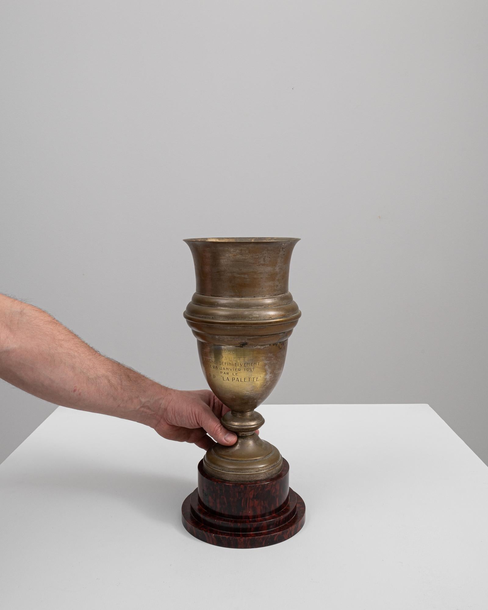 This 20th-century Belgian brass goblet embodies the essence of classic elegance with its timeworn charm. The goblet, with its flared lip and robust silhouette, harks back to a bygone era of distinguished gatherings and celebratory toasts. Its brass