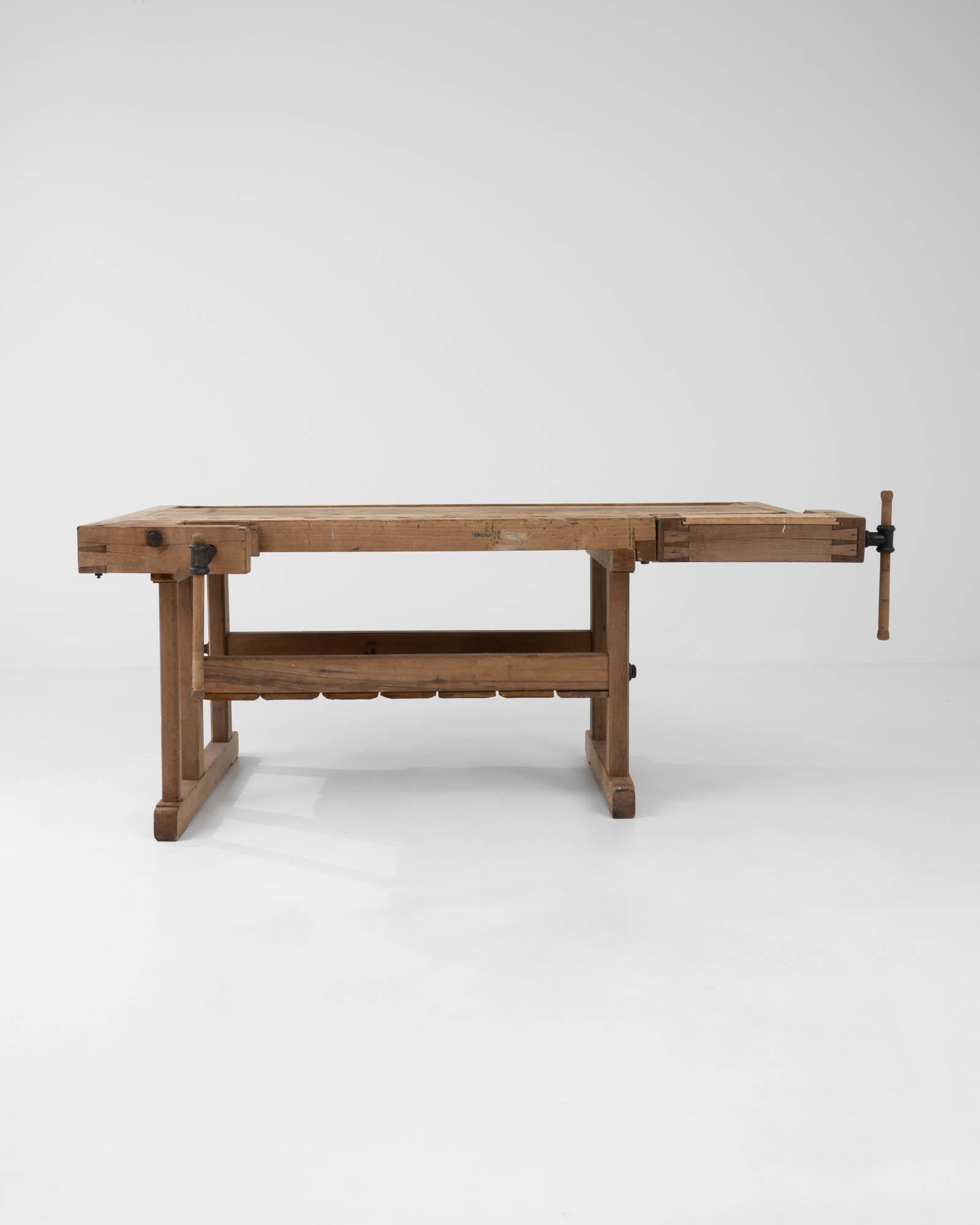With its workmanlike design and warm natural finish, this vintage wooden table makes a striking Industrial accent. Built in Belgium in the 20th century, this piece would have originally been used as a carpenter’s work bench; the impressive metal
