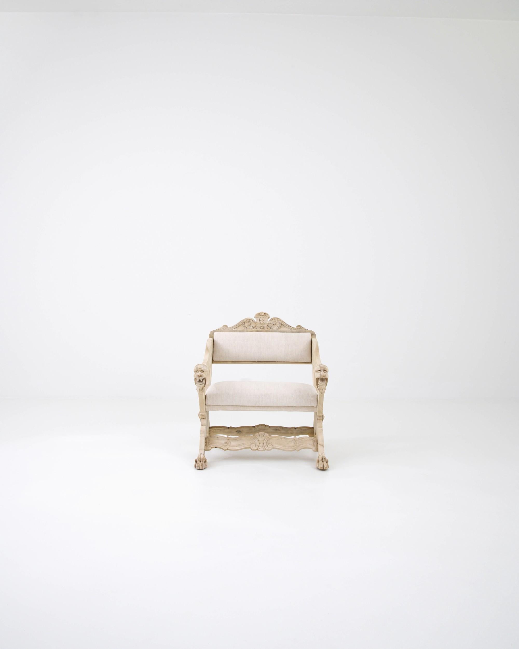 The blend of wood, bleached to a tone reminiscent of ivory, and the light upholstery of the seat gives this 20th-century Belgian armchair an exquisite accent. The wooden base showcases carved rosettes and foliate elements, with expertly executed