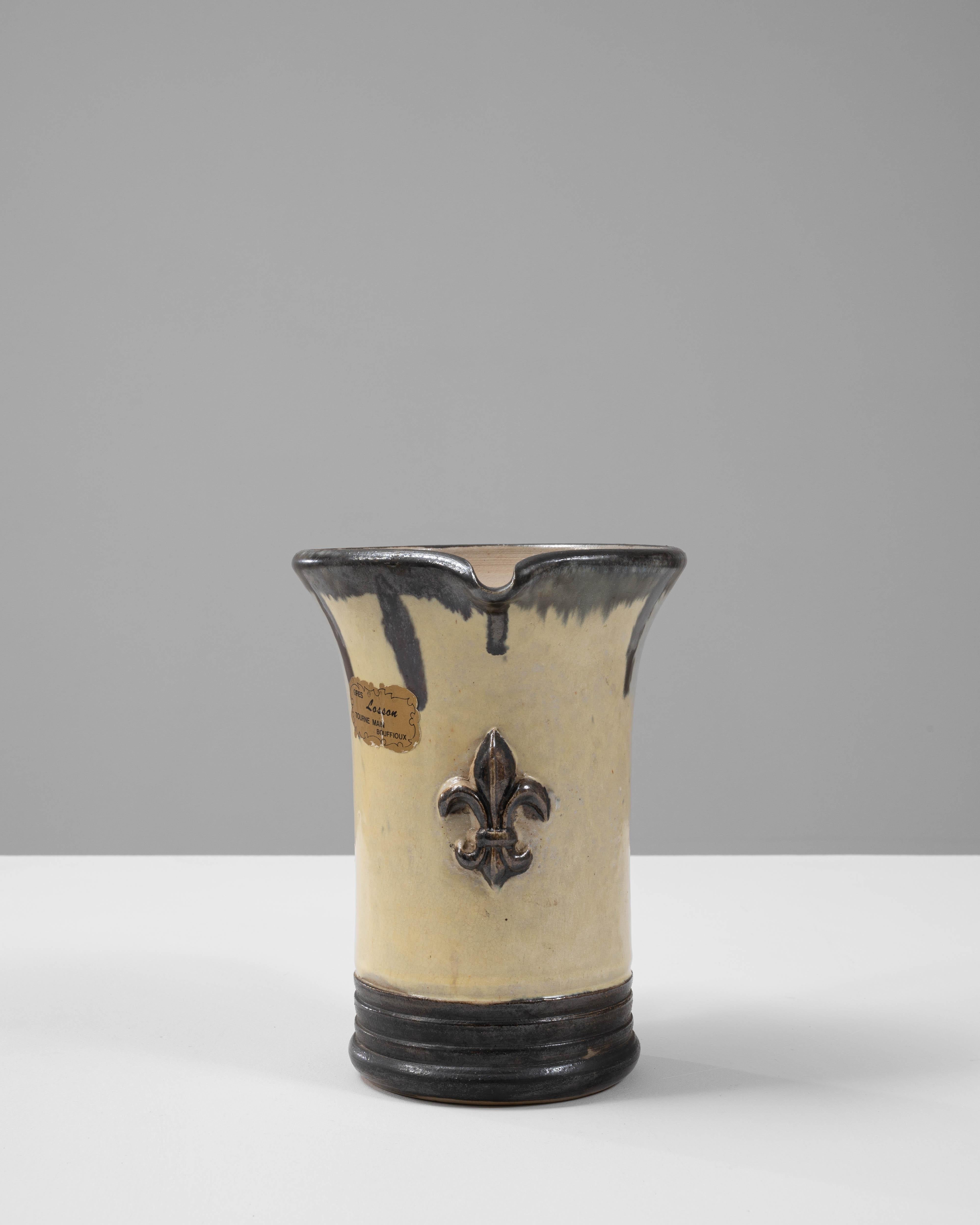 Questa elegante brocca in ceramica belga del XX secolo, opera di G. Losson, mostra una maestria artigianale e un design senza tempo. Caratterizzato da un sorprendente smalto bicolore con un corpo beige crema contrastato da audaci accenti neri, emana