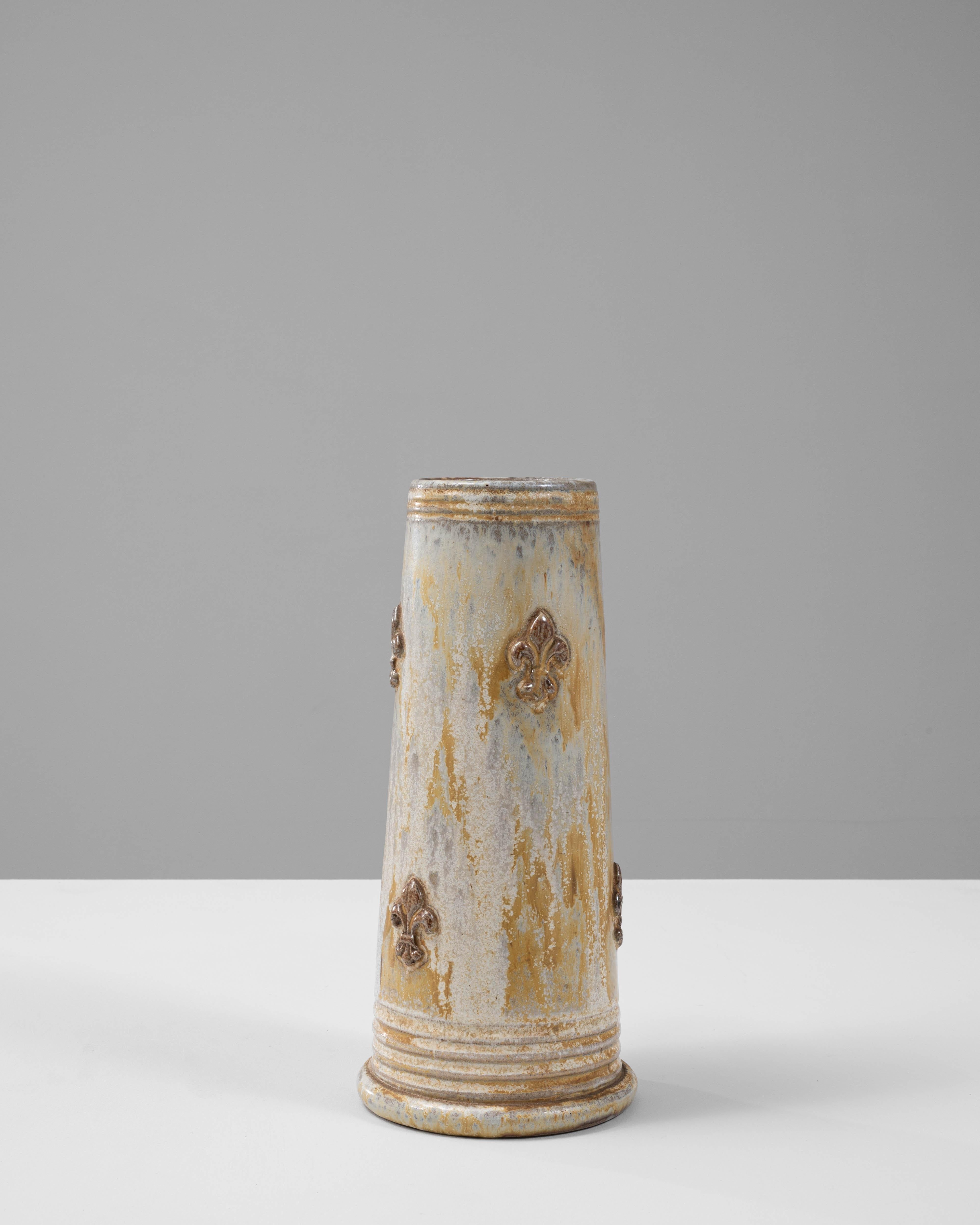 Questa caratteristica brocca in ceramica belga del XX secolo, opera di G. Losson, è uno straordinario esempio di artigianato e design. La forma conica allungata è impreziosita da uno smalto ricco e terroso che passa dai toni morbidi del beige e del