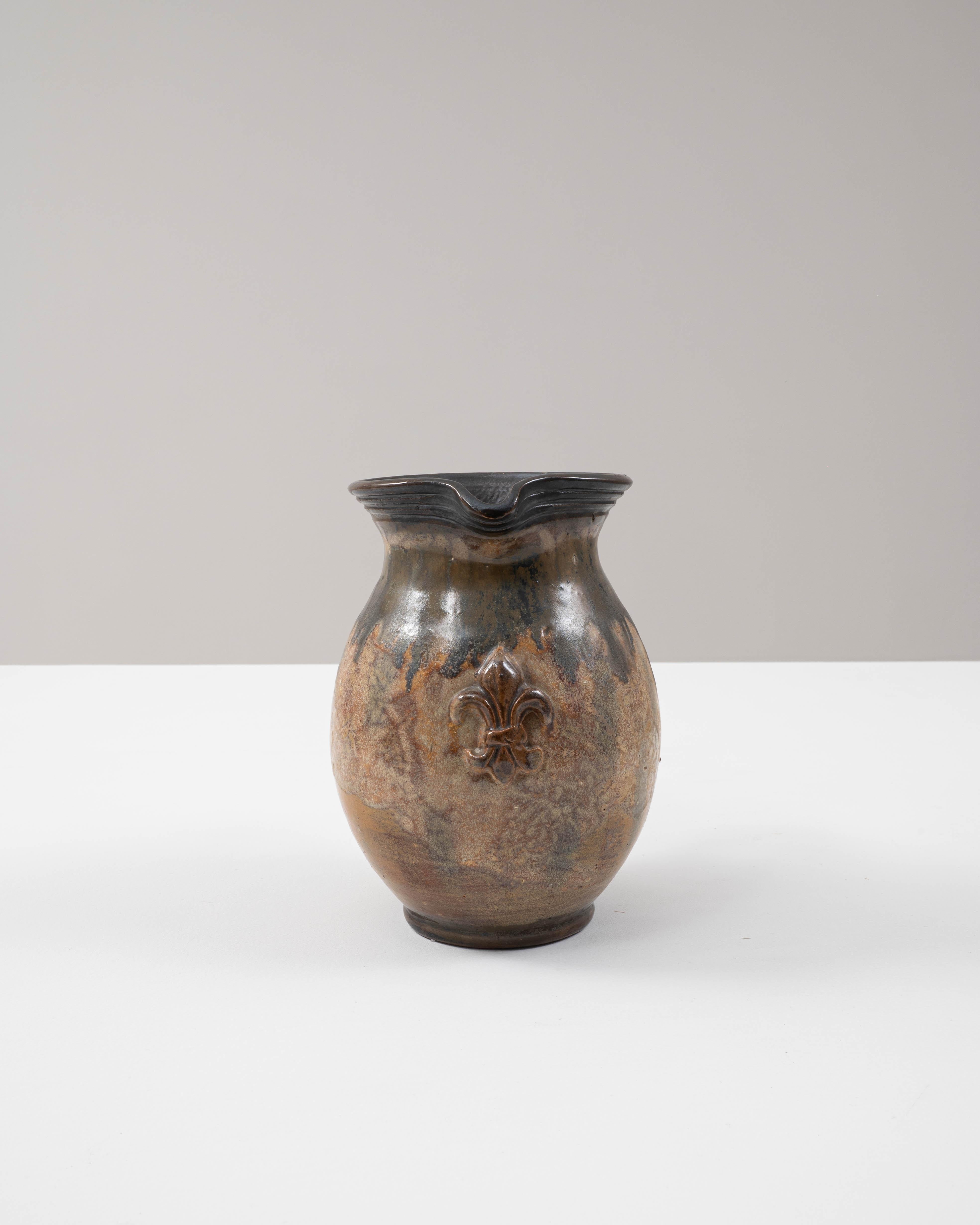 Questa squisita brocca in ceramica belga del XX secolo, opera di G. Losson, esemplifica la maestria e l'artigianato del suo tempo. La forma arrotondata presenta uno smalto strutturato nei toni del marrone e del verde, creando una finitura