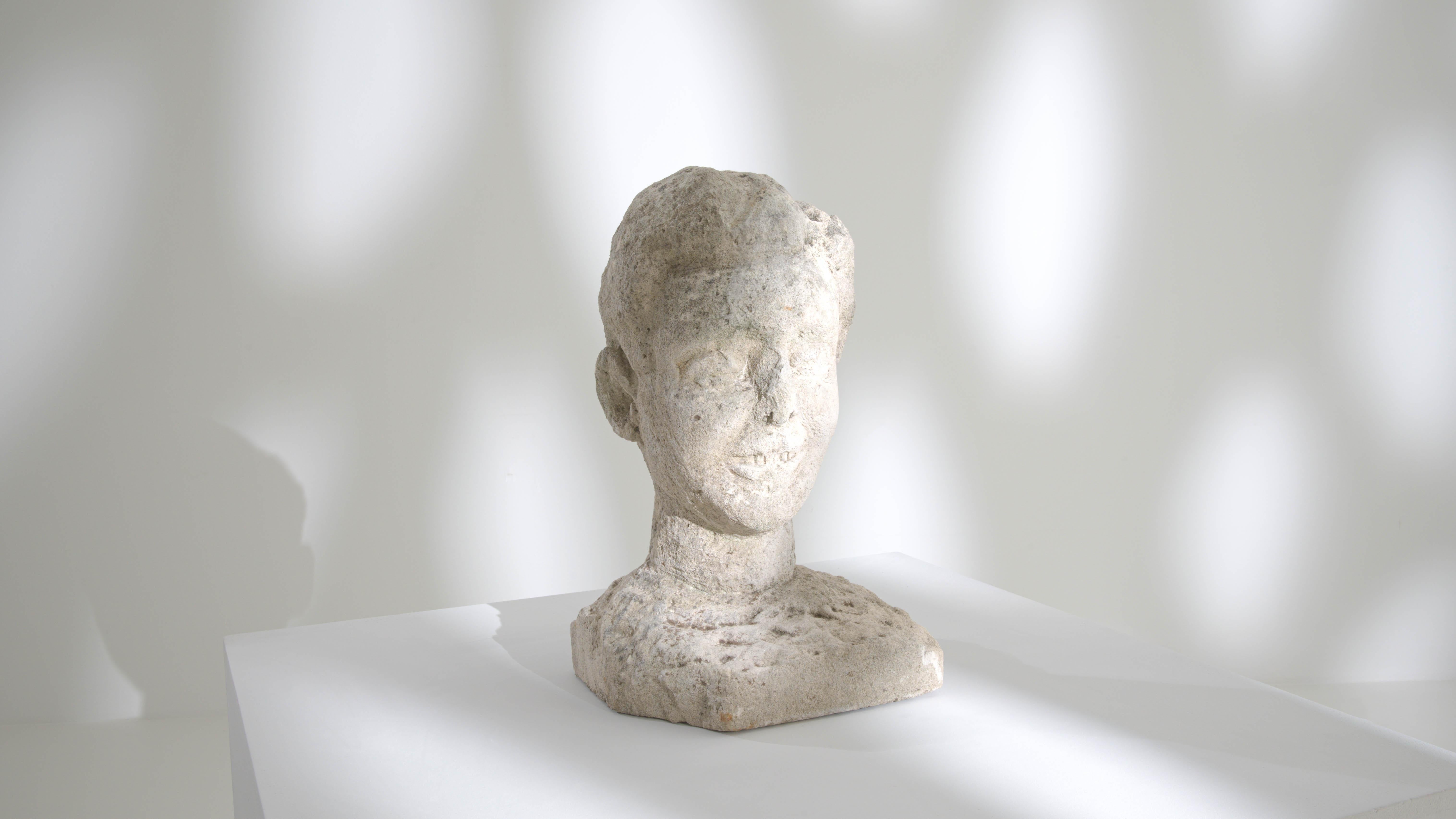 Capture the timeless essence of the 20th century with this Belgian Concrete Bust, a striking representation of a young adult male with a captivating smile. The weathered patina, a testament to the passage of time, adds character and depth to the