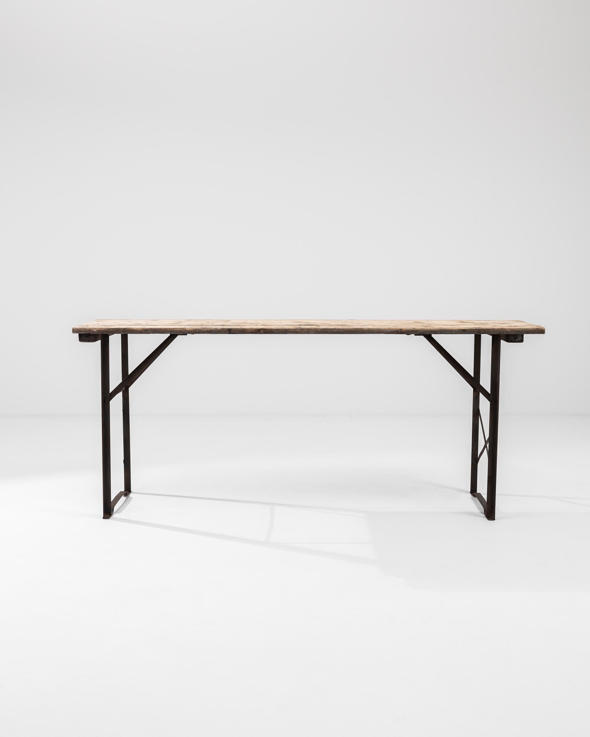 Light and versatile, this Industrial table offers an elegantly functional vintage piece. Made in Belgium in the 1900s, the angular struts of the metal frame have a graphic simplicity. Above, a simple tabletop of wooden boards adds a rustic note. The