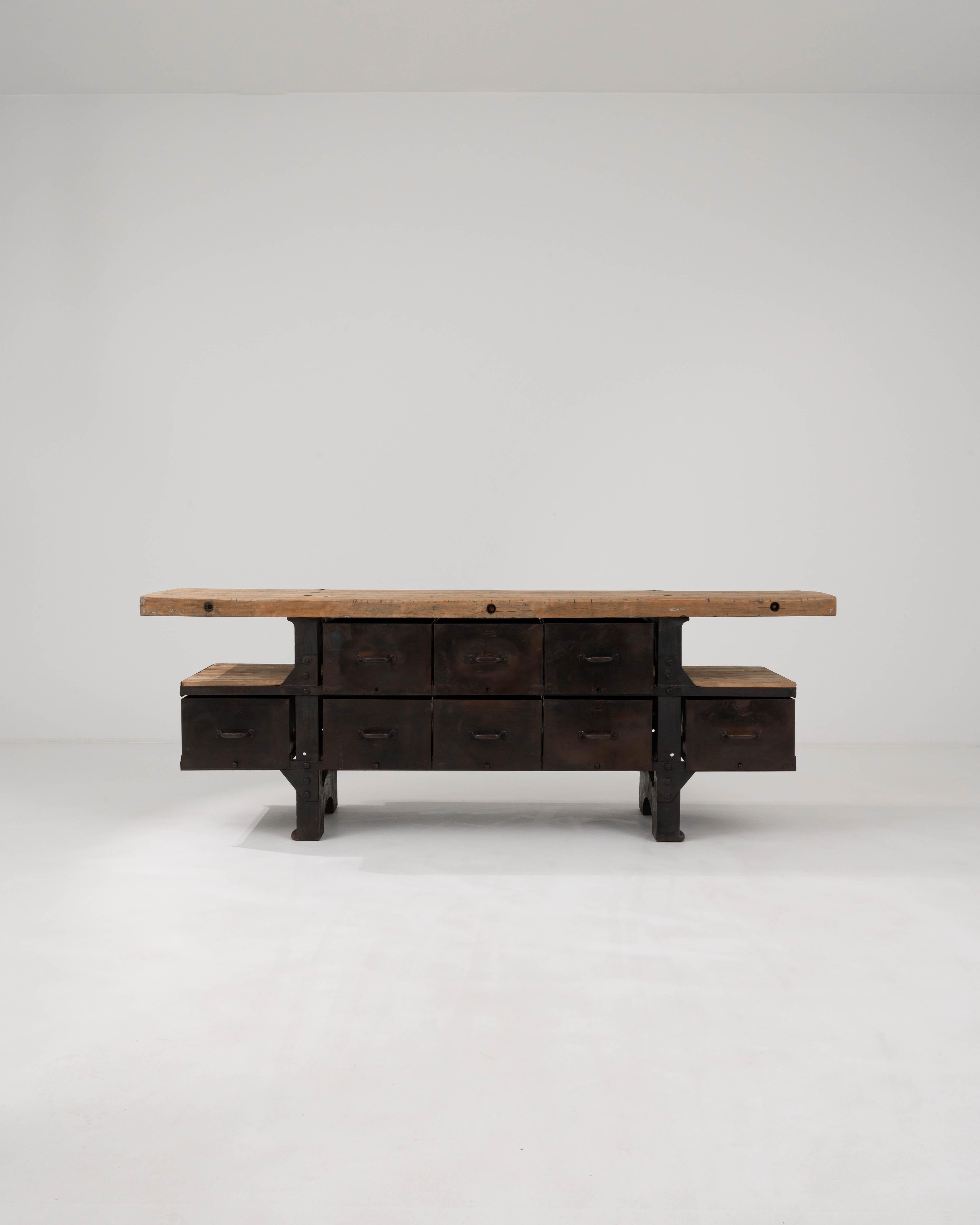 Cette table industrielle belge du 20e siècle est un ajout robuste à tout espace qui apprécie l'esthétique brute et non raffinée du design industriel. Le plateau de la table en bois, usé par le temps et l'usage, porte les marques et les histoires