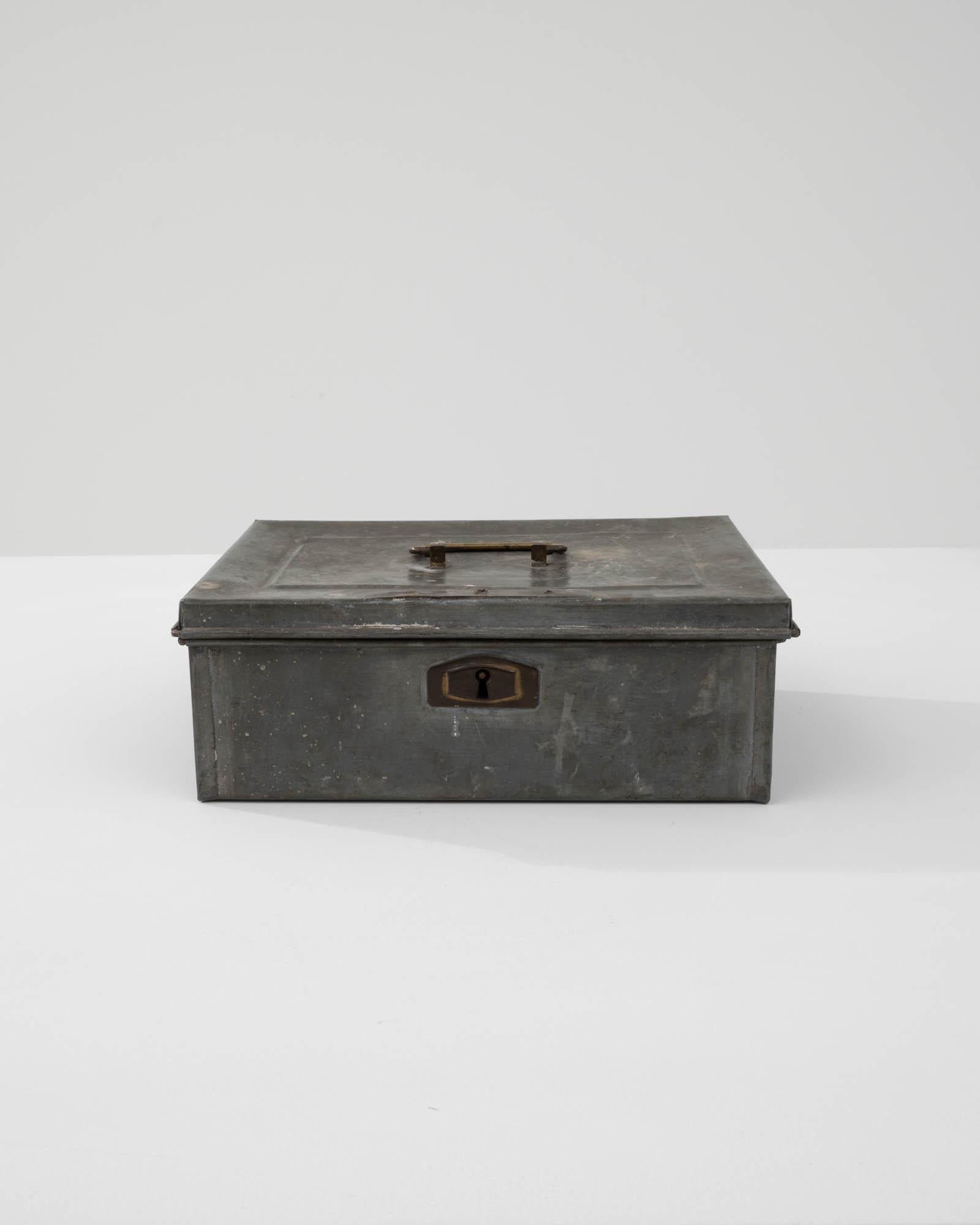 Delve into the industrial elegance of the early 20th century with this authentic Belgian metal box. Constructed with the durability of the era, this piece features a weathered patina that adds depth and character, hinting at the storied past of a