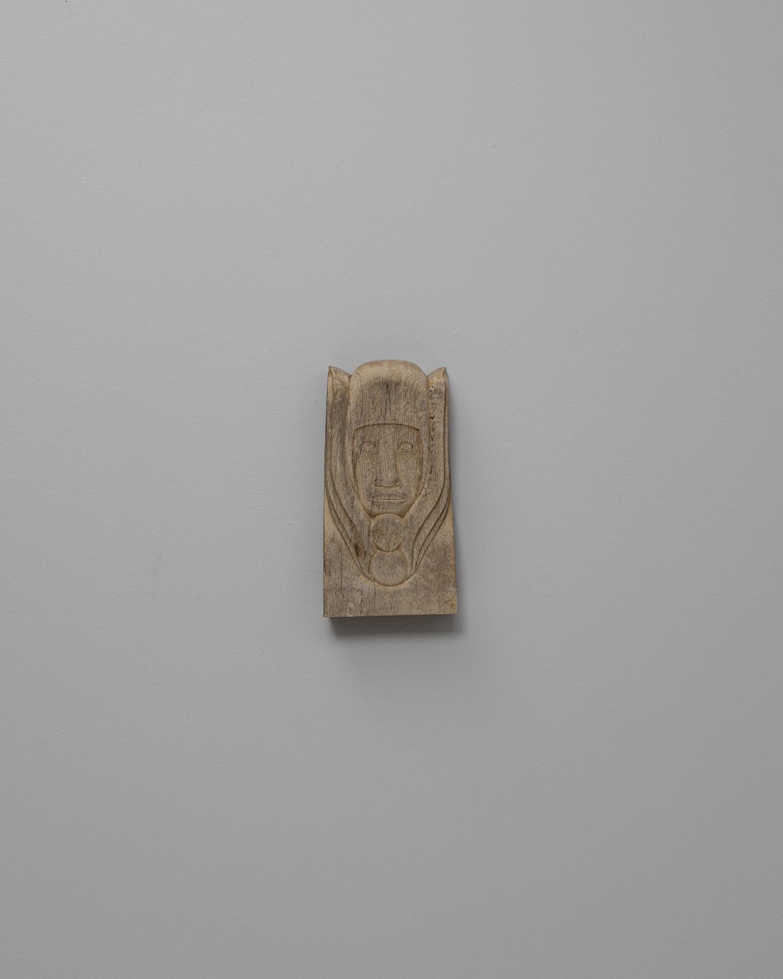 Art mural en chêne belge du 20e siècle. Ce relief en chêne sculpté à la main représente un visage humain stylisé encadré par des lignes douces et fluides, avec un motif abstrait de hibou placé en dessous. La composition reflète une influence