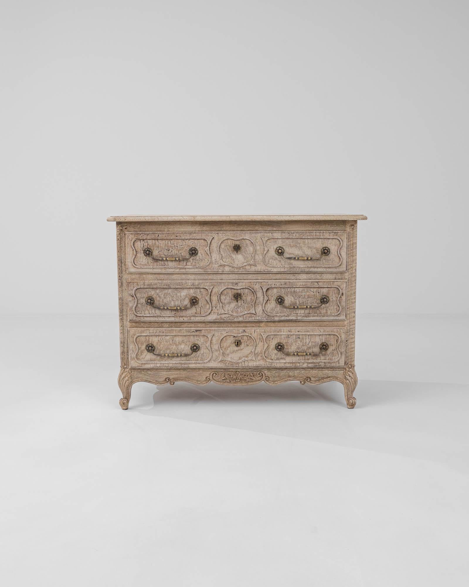 Inspired by flamboyant Baroque aesthetics, this exquisite three-drawer chest features graceful cabriole legs adorned with meticulous scroll and foliate carved accents that continue onto the scalloped apron.The dresser was handcrafted in 20th-century