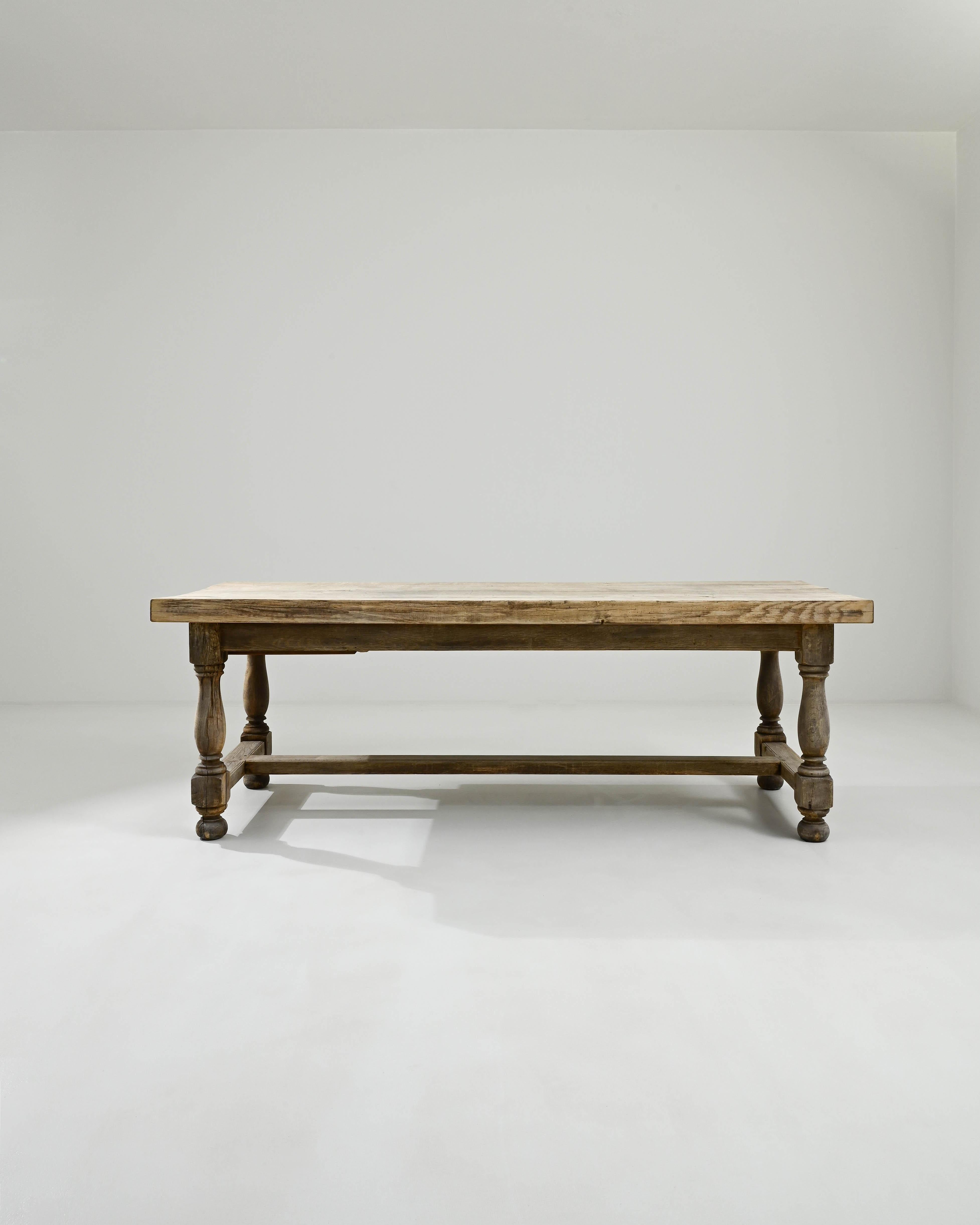 Solid and statuesque, this vintage oak dining table makes a magnificent Provincial centerpiece. Built in Belgium in the 20th century, carved ball feet and gracefully contoured legs create an attractive profile, lending an elegant inflection to the
