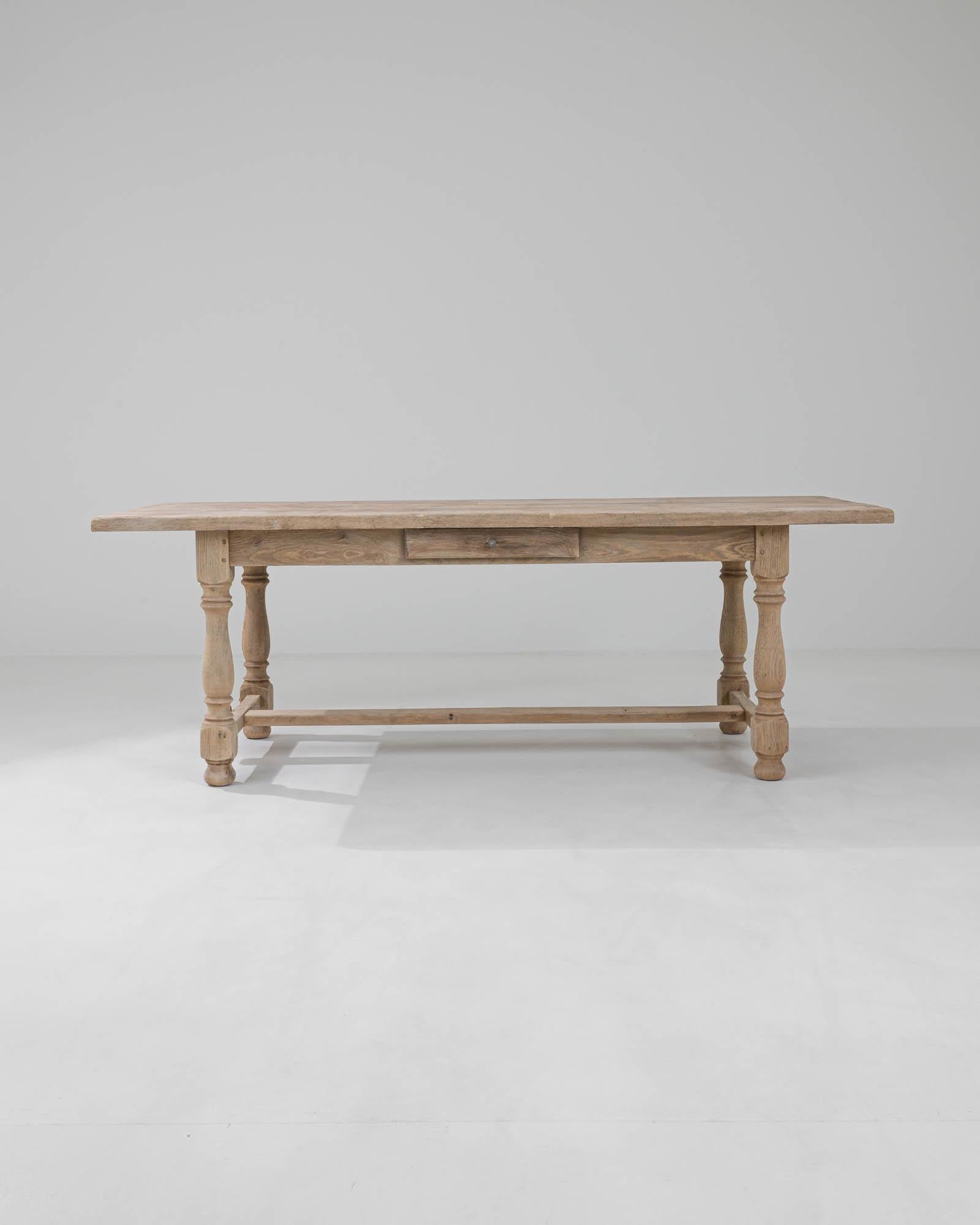 A simple country design in natural oak gives this vintage dining table a timeless charm. Hand-built in Belgium in the 20th century, the pinned tennon stretcher announces the quality construction, while the turned legs brings elegance to the