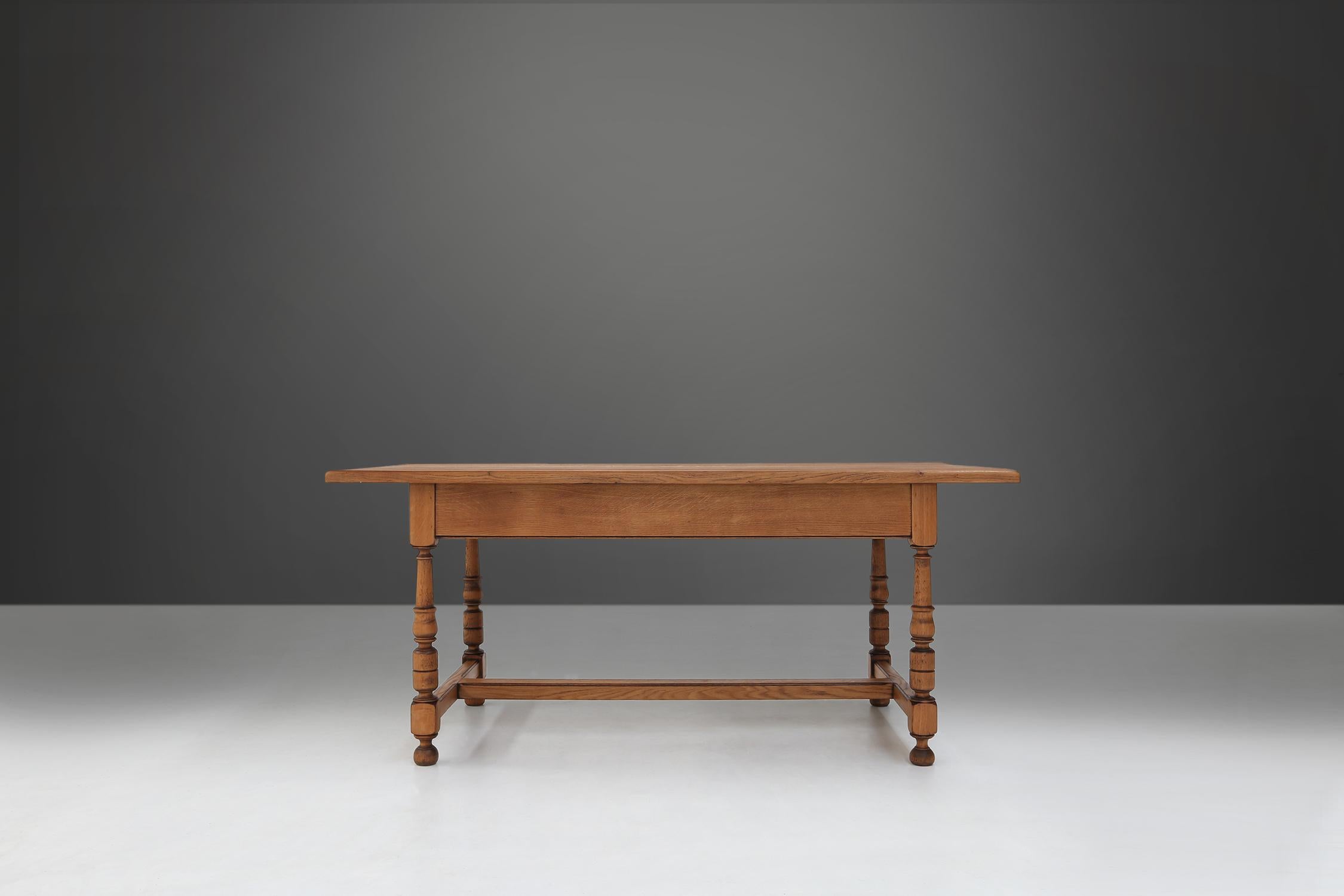 Cette table du XXe siècle est fabriquée en bois de chêne de haute qualité et a une finition brun clair. Les pieds sont torsadés et ont une forme sphérique, ce qui confère à la table un aspect élégant et classique.

Le chêne a une brillance naturelle