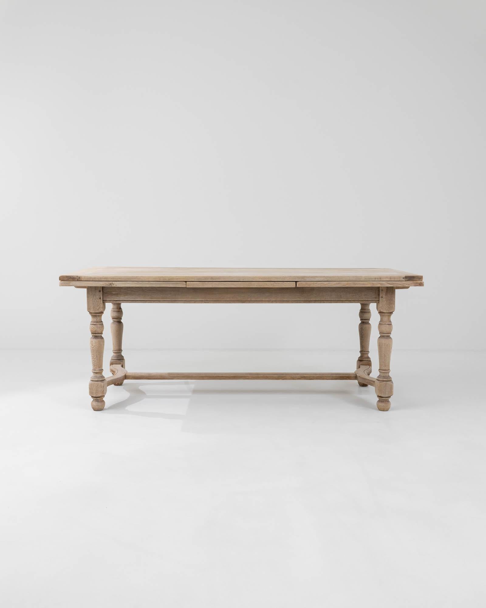 A simple country design in natural oak gives this vintage dining table a timeless charm. Hand-built in Belgium in the 20th century, turned legs create an attractive profile, while the sinuous curve of the lower struts brings elegance to the