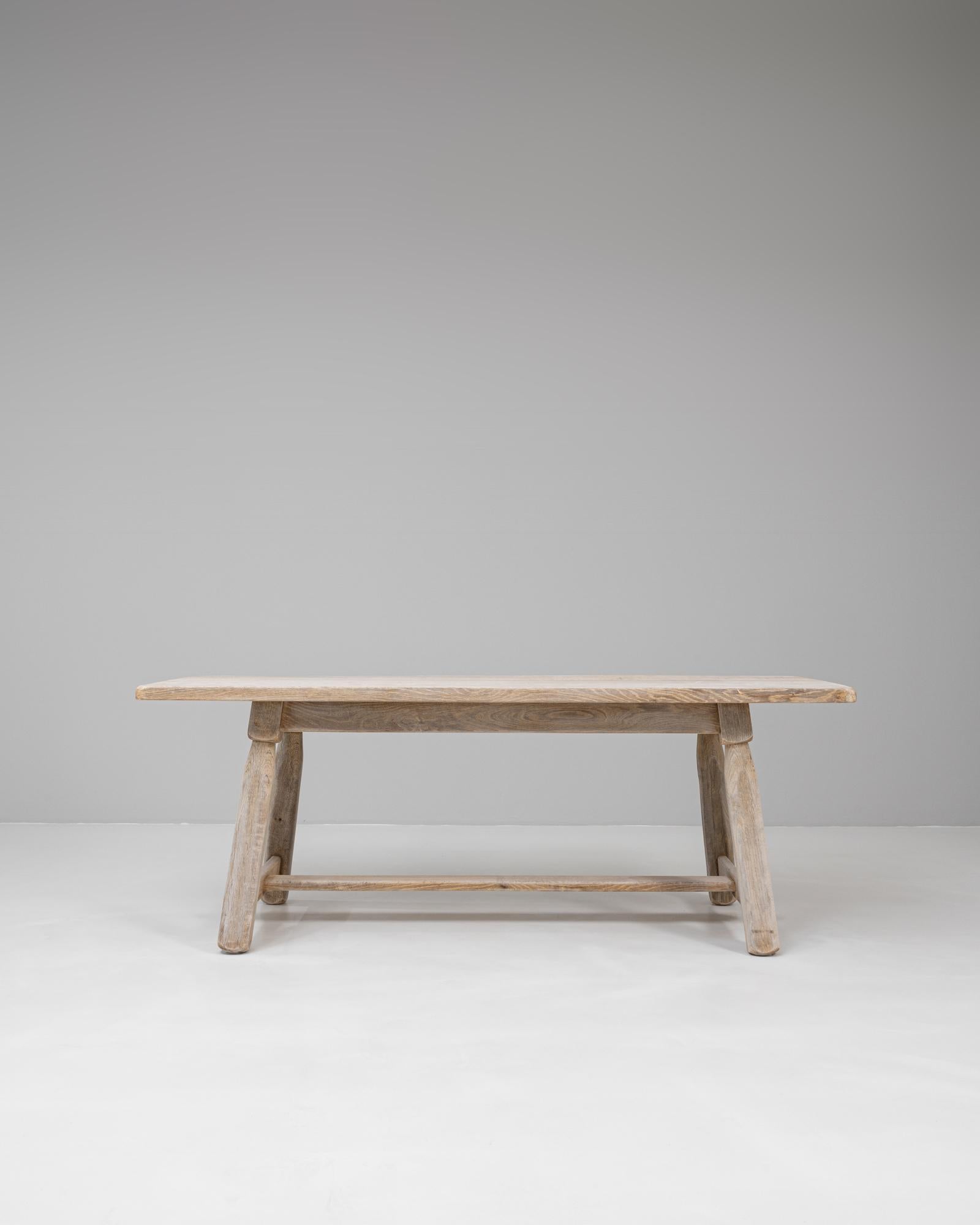 Table de salle à manger en chêne belge du 20e siècle à pieds évasés, illustrant la force et le savoir-faire discrets du design belge traditionnel. La construction en chêne massif comprend un épais plateau rectangulaire soutenu par des pieds robustes