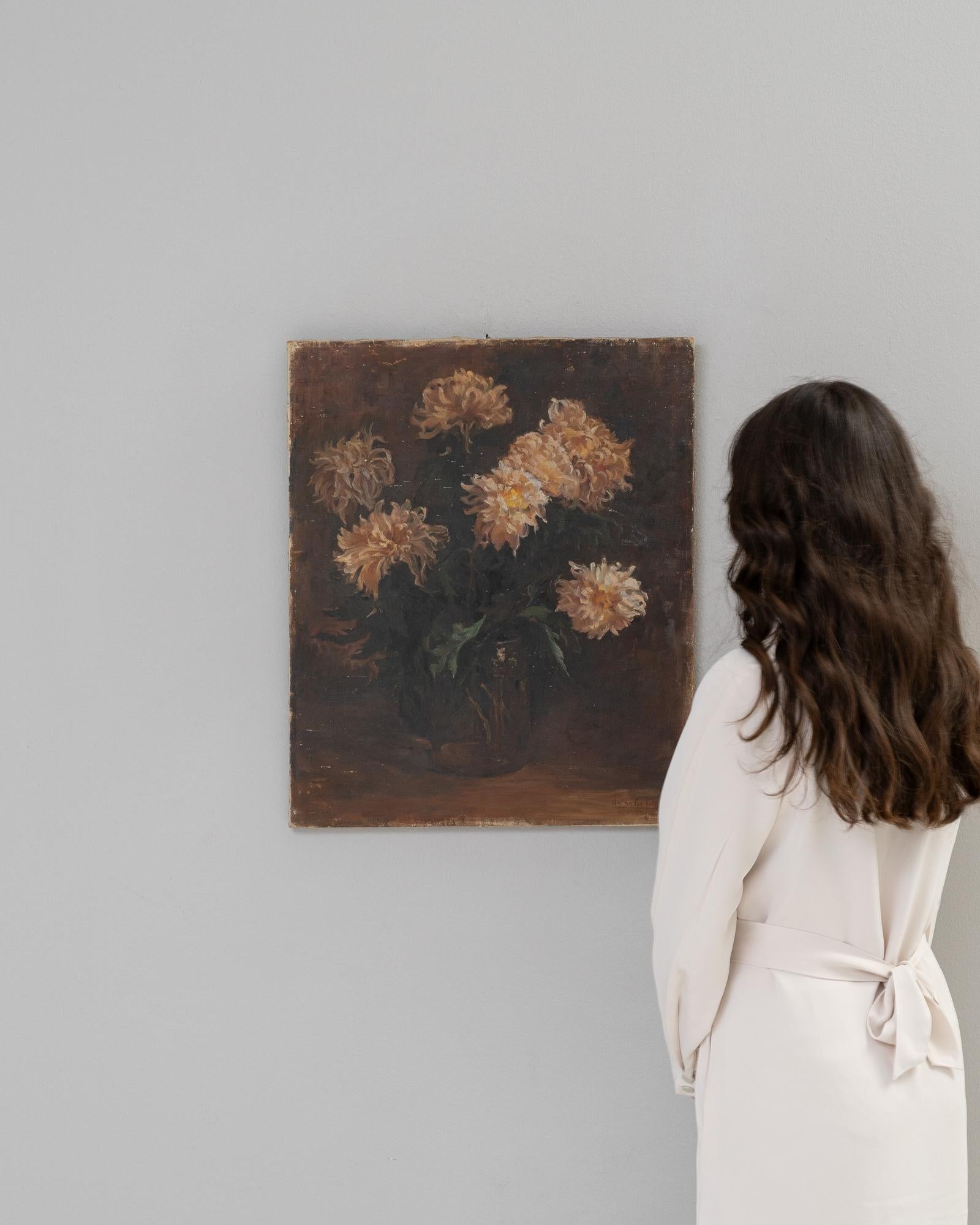 Cette peinture belge du XXe siècle représente un bouquet de chrysanthèmes en pleine floraison, dont les pétales forment une symphonie de teintes dorées et ambrées qui donnent de la chaleur à la toile. L'arrière-plan sombre contraste fortement avec