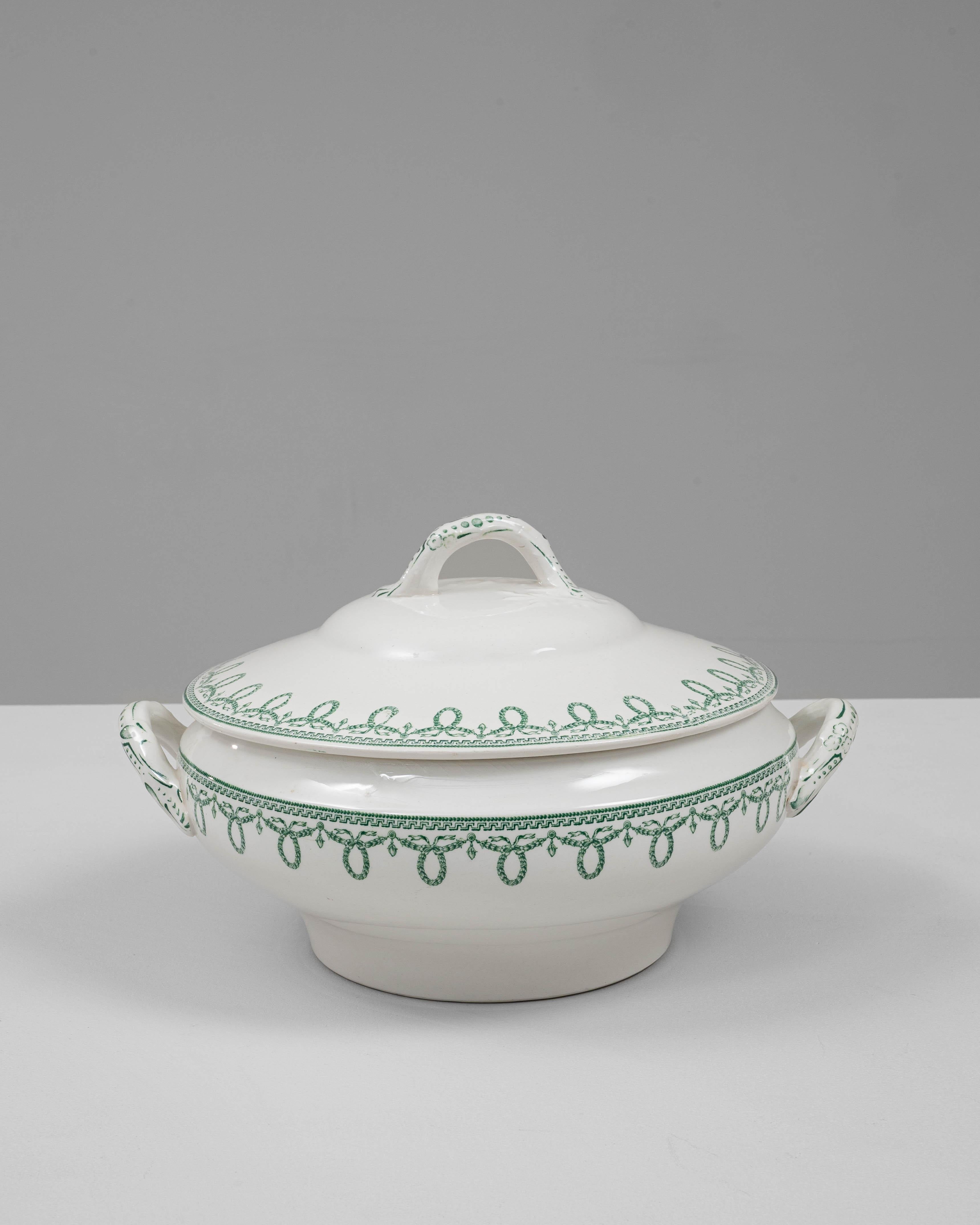 Cette soupière en porcelaine belge du XXe siècle, édition spéciale avec couvercle, présente l'élégance raffinée et les détails délicats caractéristiques de la vaisselle européenne classique. Réalisée en porcelaine lisse de couleur ivoire, la pièce