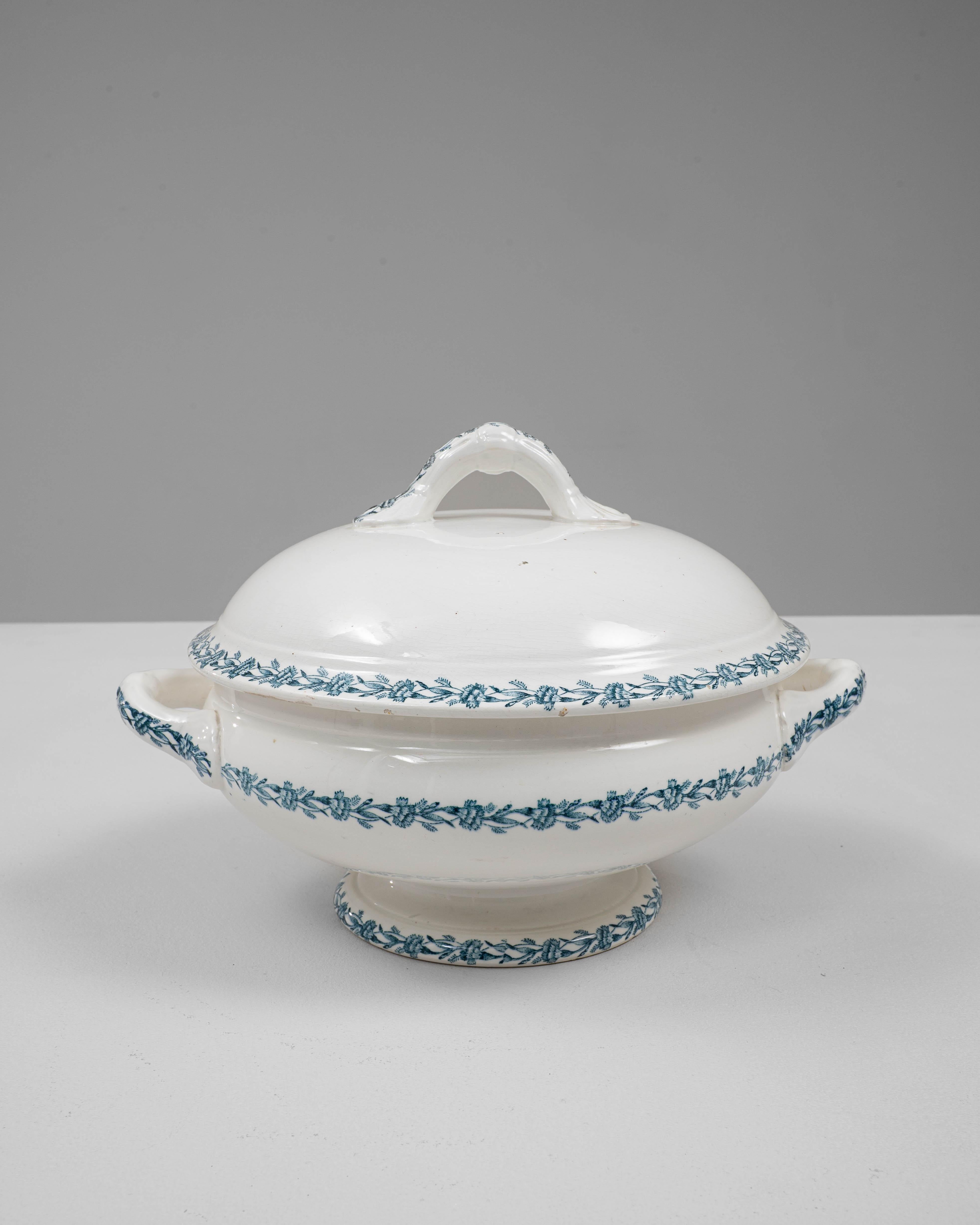 Cette soupière en porcelaine belge du XXe siècle, édition spéciale avec couvercle, présente l'élégance raffinée et les détails délicats caractéristiques de la vaisselle européenne classique. Réalisée en porcelaine lisse de couleur ivoire, la pièce