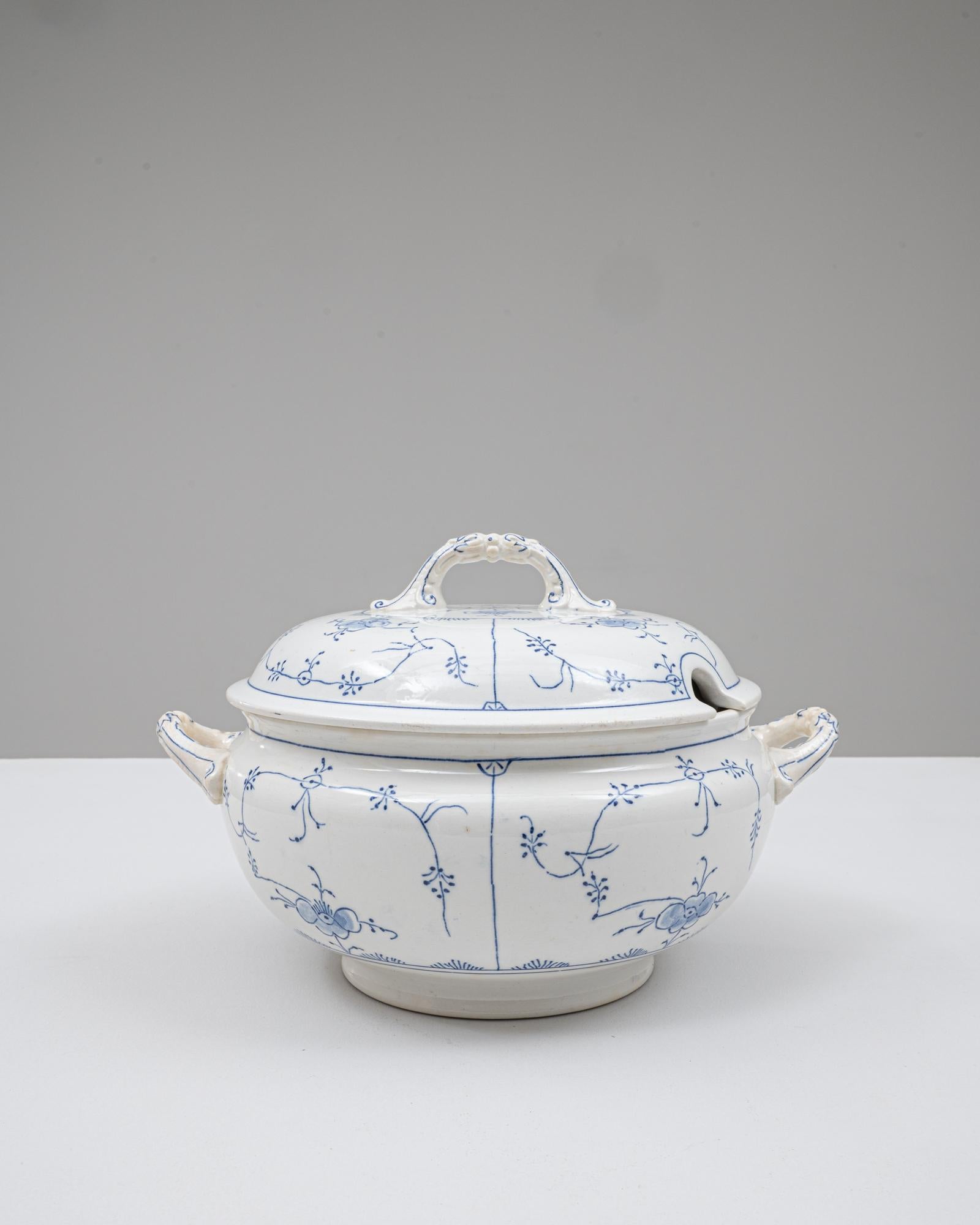 This 20th Century Belgian special edition porcelain tureen features an elegant rounded form accented by delicate blue linework in a refined floral and scroll motif. The domed lid includes a sculpted loop handle and a ladle notch, highlighting its