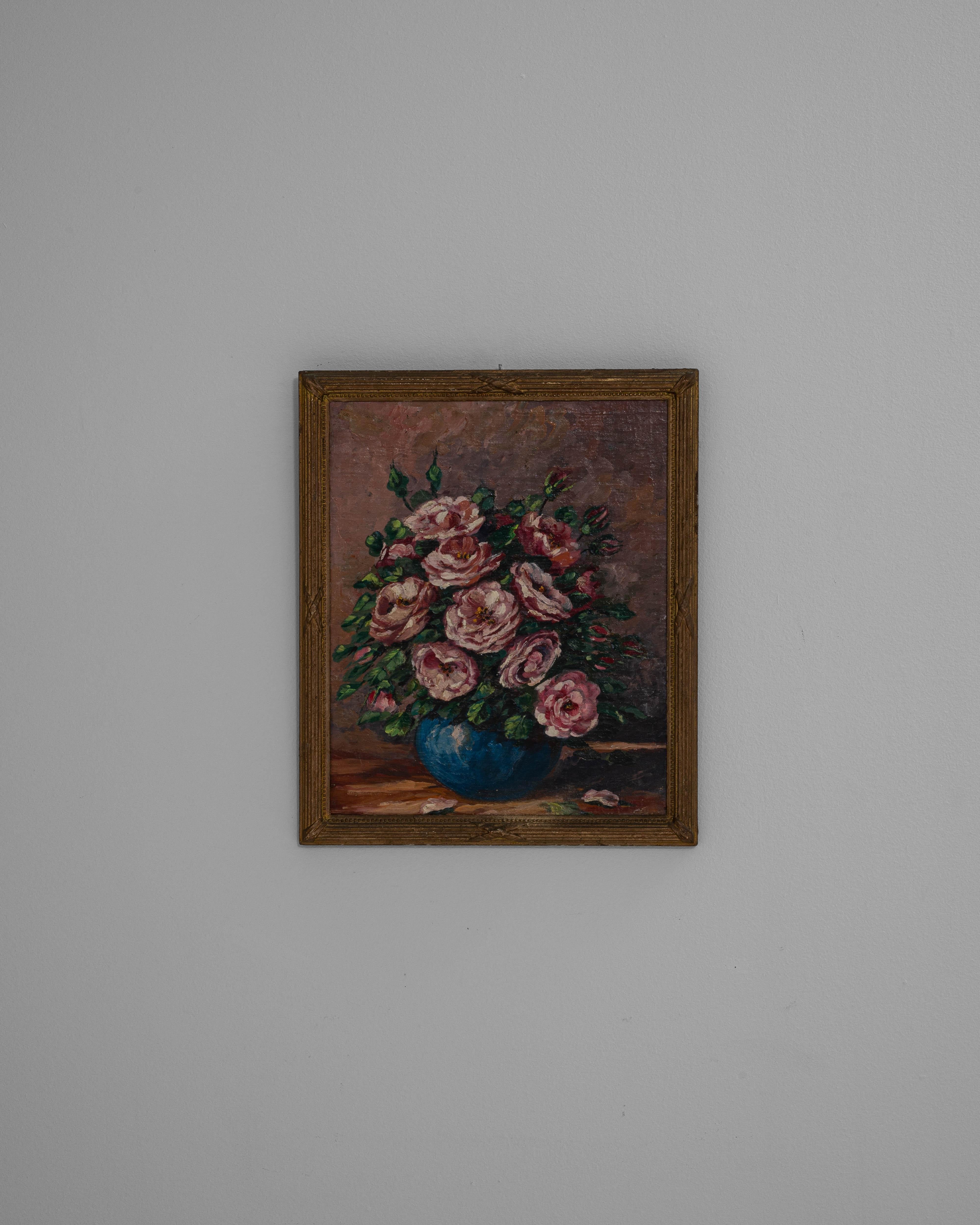 This 20th-century Belgian still life painting captures a delicate bouquet of pink camellias arranged in a vibrant blue vase. Rendered in oil on canvas, the composition highlights the soft textures and rich tones of the blossoms against a muted