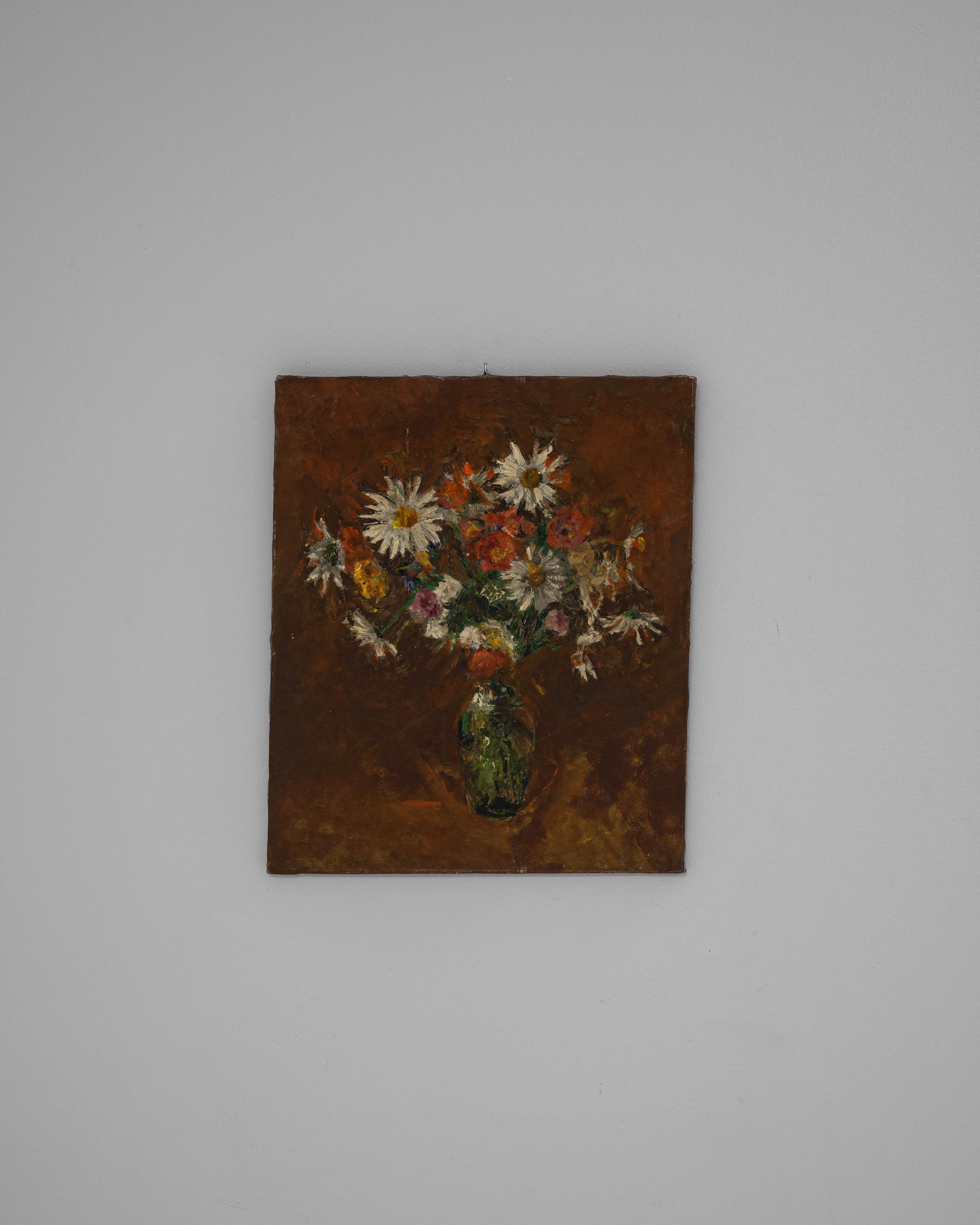 This 20th century Belgian still life painting presents a charming bouquet of wildflowers arranged in a green glass vase. The artist uses bold, textured brushstrokes and a rich, earthy background to highlight the white daisies, warm oranges, and