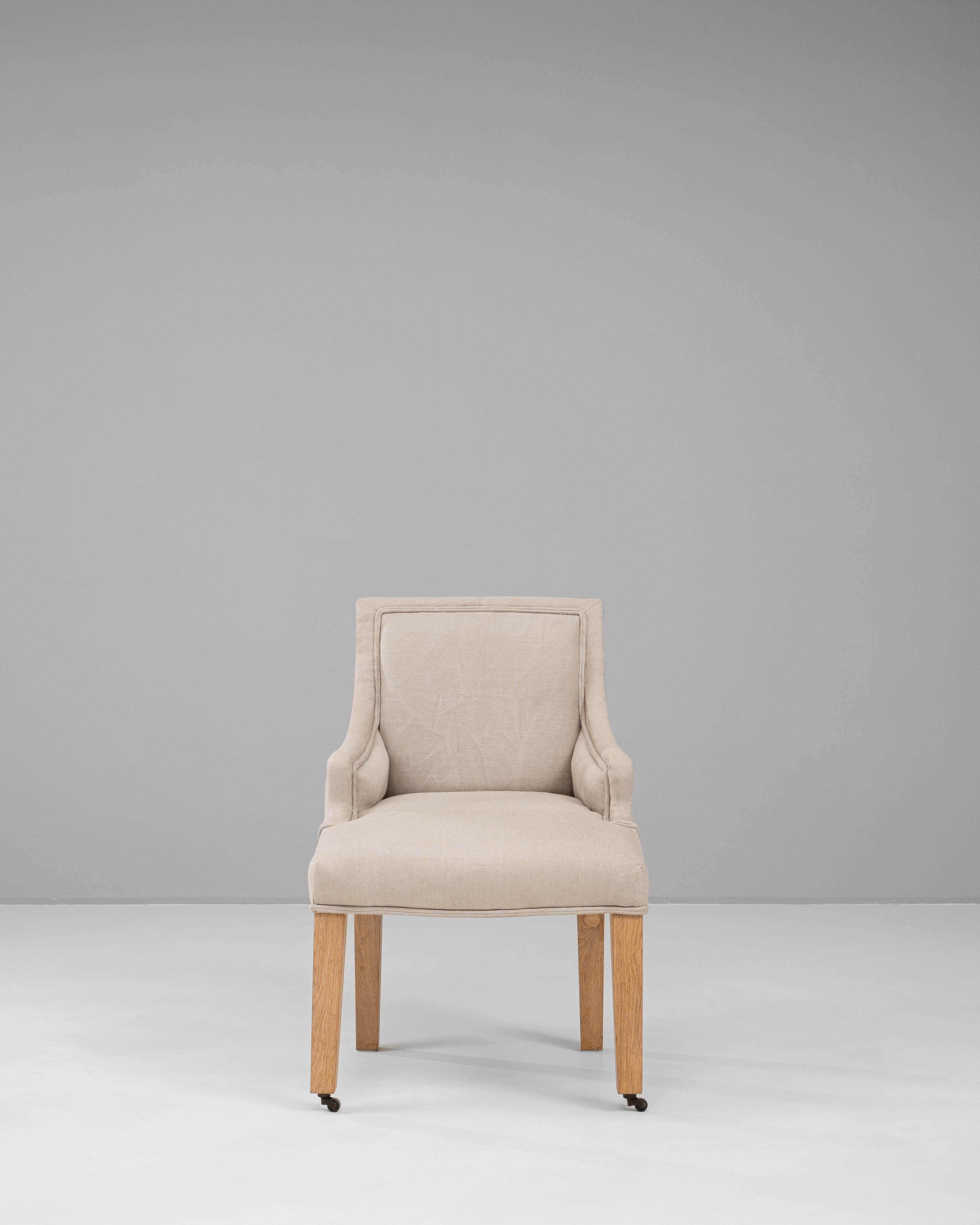 Ce fauteuil rembourré belge du 20e siècle présente un mélange harmonieux de confort et d'élégance, avec une finition en tissu neutre qui s'harmonise avec une variété d'intérieurs. Conçue dans un souci de style et de fonctionnalité, la chaise repose