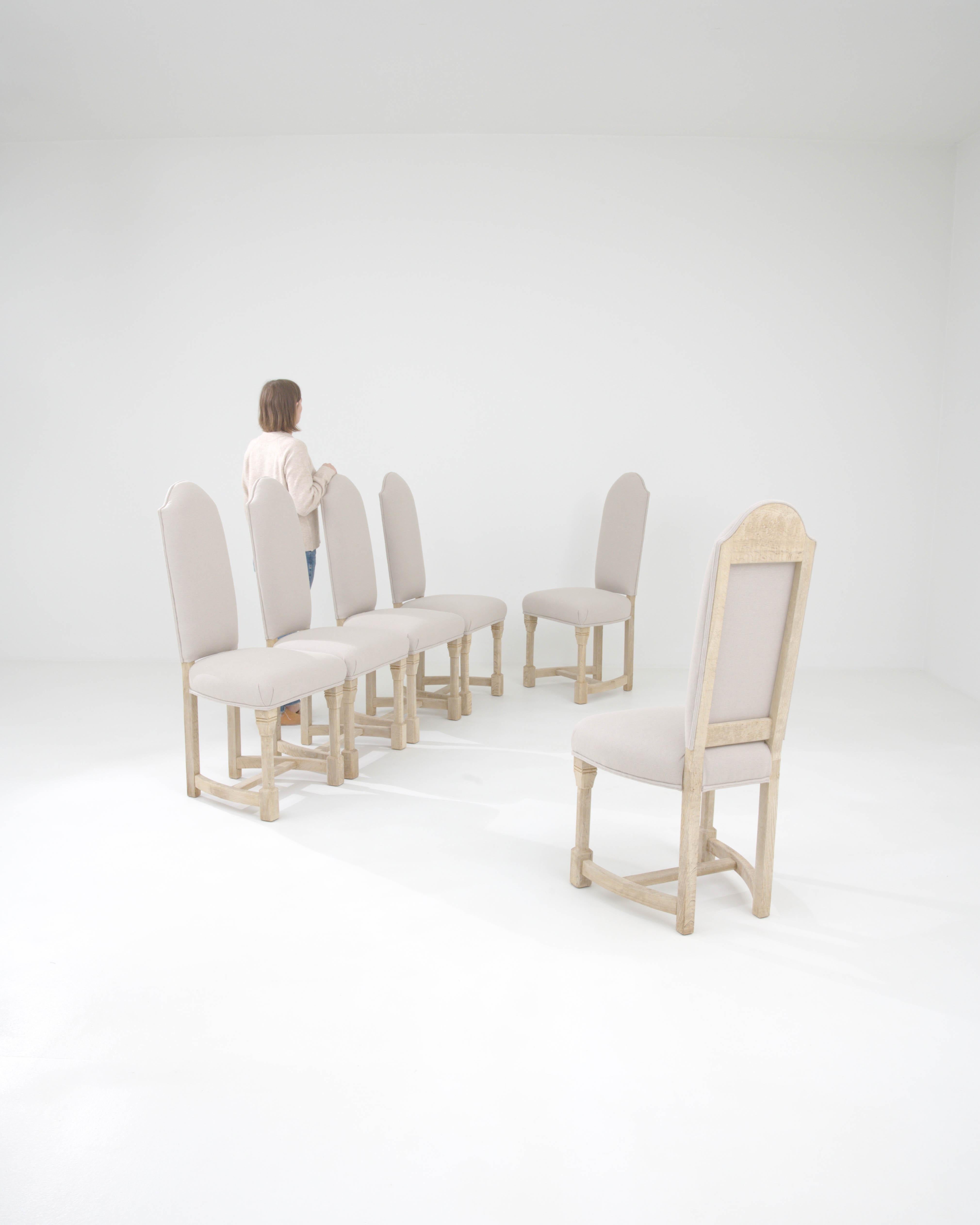 Elevate your dining experience with this exquisite set of six 20th Century Belgian Upholstered Dining Chairs. Each chair is a masterpiece of understated luxury, with a gracefully high backrest that offers both support and a regal silhouette. The