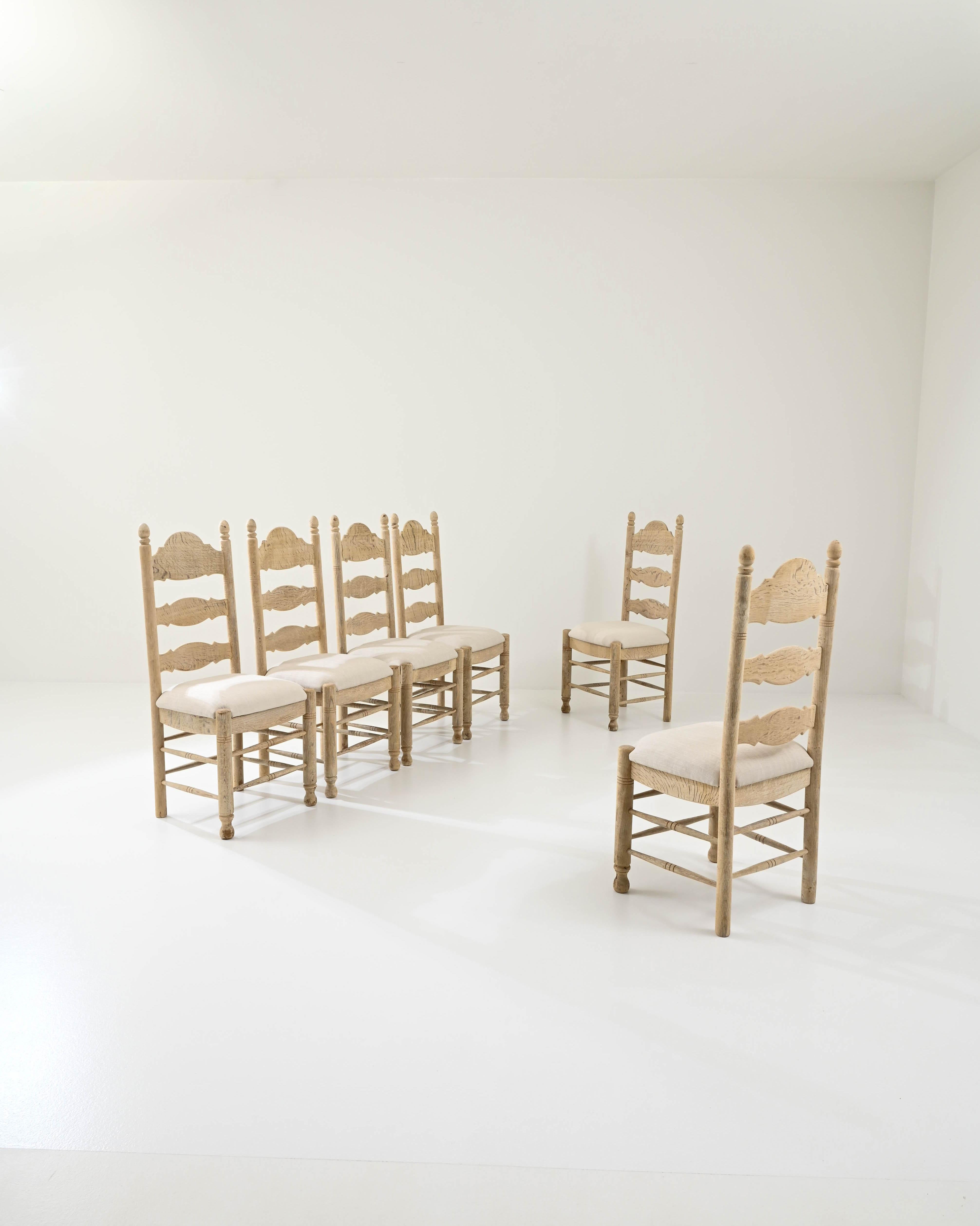 Une silhouette de ferme et une palette de couleurs naturelles apaisantes confèrent à cet ensemble de chaises de salle à manger en bois vintage un charme accueillant. Fabriqués en Belgique au XXe siècle, les dossiers profilés apportent une touche