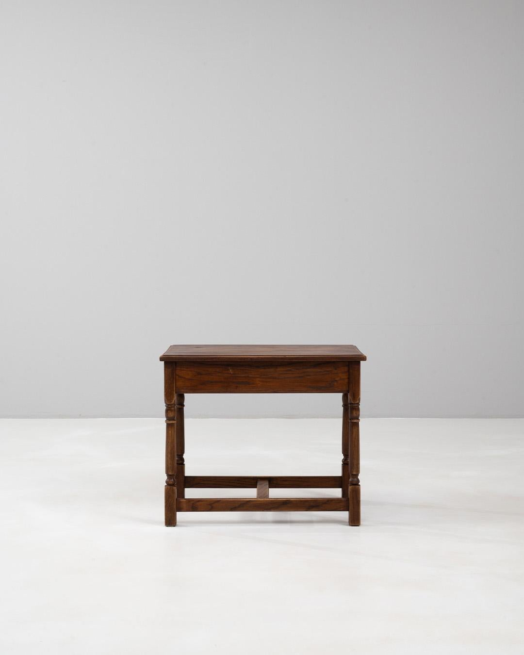 Table basse en bois belge du 20e siècle qui a conservé sa belle patine d'origine, témoignant de la qualité et de l'authenticité de son exécution. La construction en bois massif présente un plateau rectangulaire aux bords doucement arrondis, soutenu