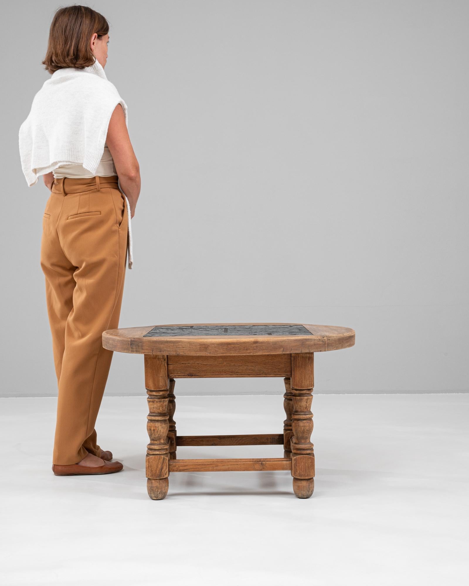 Cette table basse en bois belge du 20e siècle est une pièce magnifiquement fabriquée, dotée d'un cadre en chêne naturel et d'un plateau carré en ardoise, offrant un mélange sophistiqué d'esthétique rustique et moderne. Les pieds en bois robustes