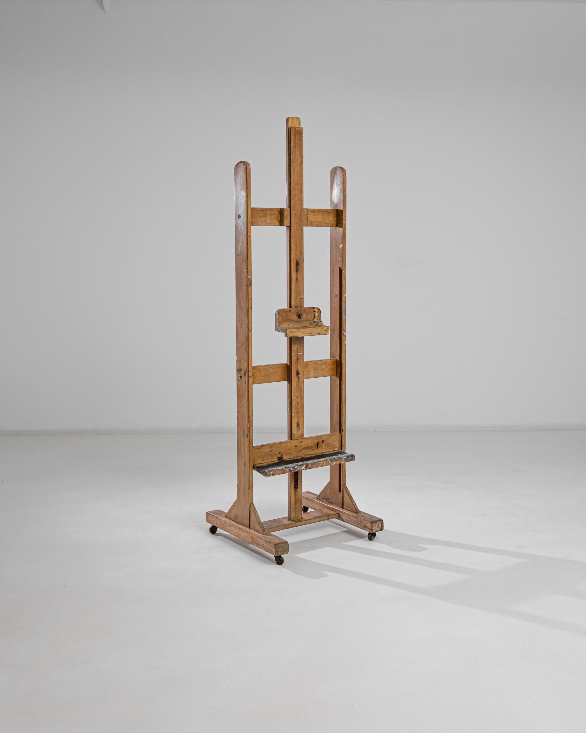 This wooden easel provides a bohemian accent or a practical accessory with a nostalgic touch. Built in Belgium in the 20th century, a pair of adjustable stands allow the frame to accommodate all sizes of canvases and drawing boards, while the