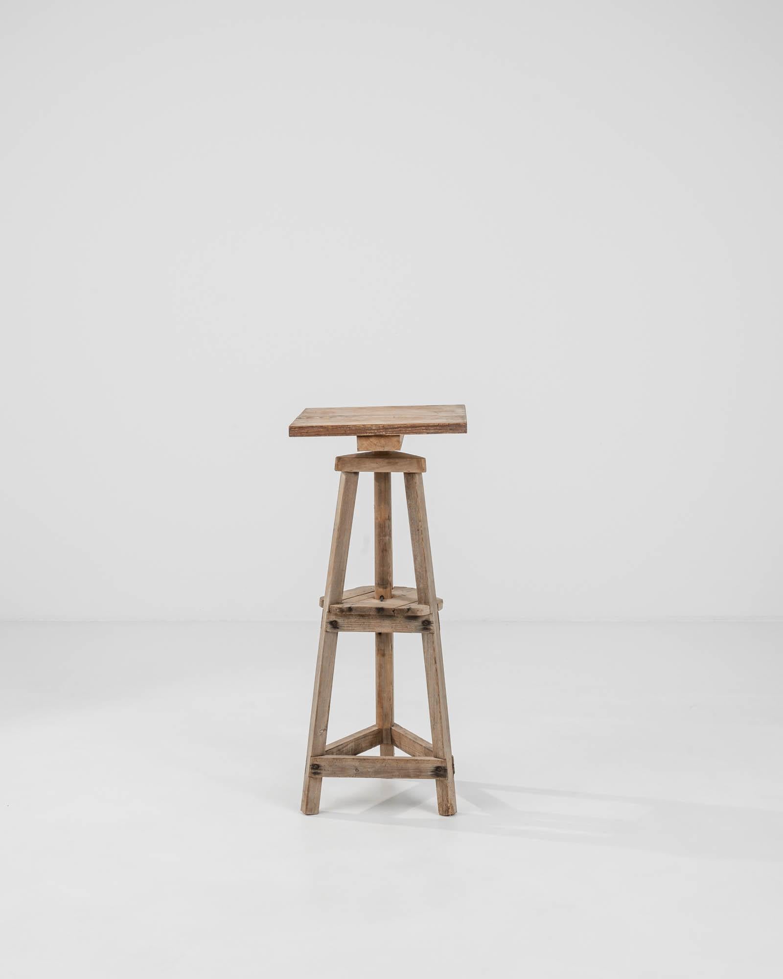 Elevate your space with this authentic 20th Century Belgian Wooden Pedestal, a piece that artfully marries rustic charm with functionality. Crafted from sturdy, aged wood, this pedestal stool showcases the natural grain and imperfections that make