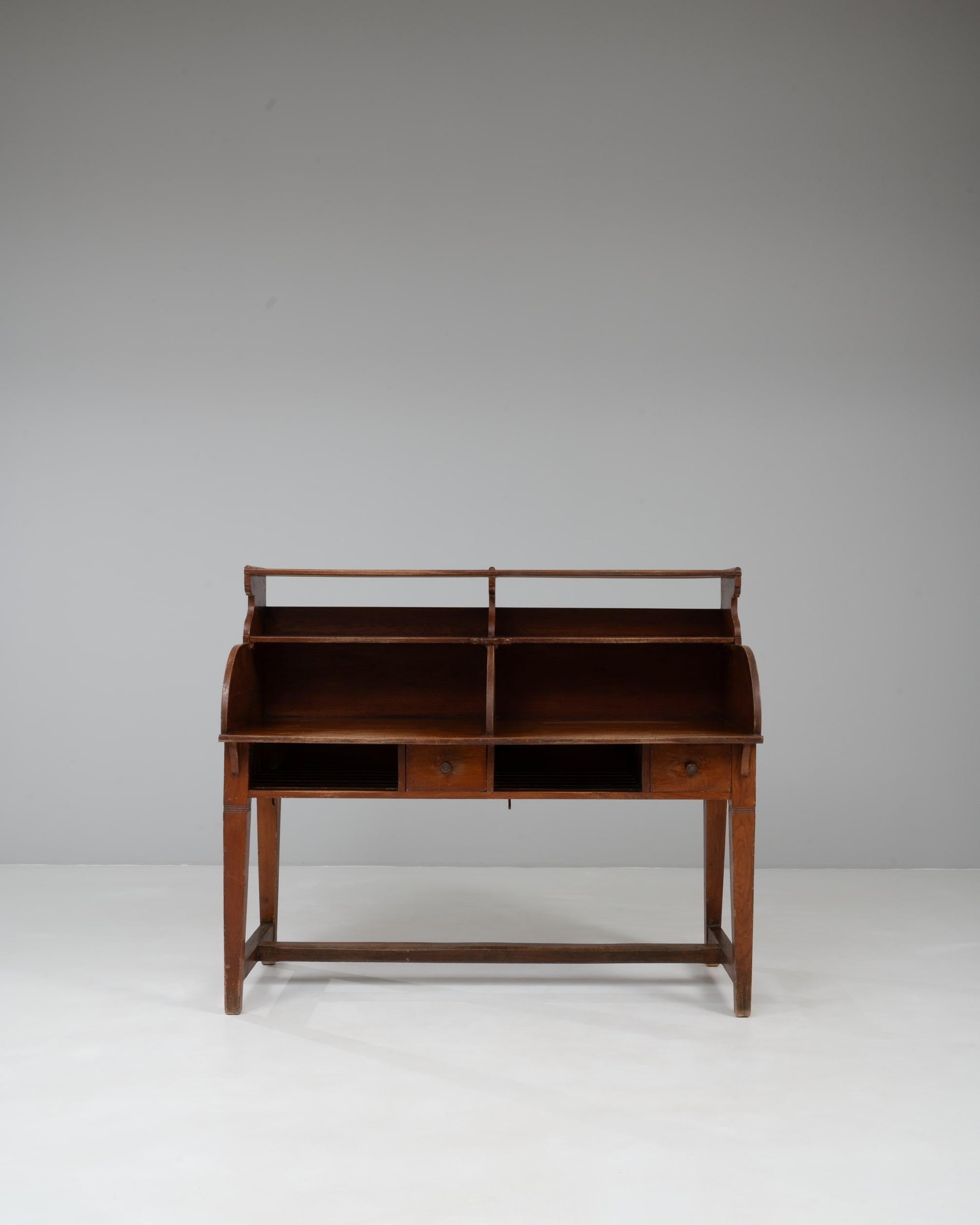 Dieser belgische Holzschreibtisch aus dem 20. Jahrhundert mit originaler Patina hat einen unverwechselbaren, utilitaristischen Charme, der auf das frühe Design von Arbeitsplätzen zurückgeht. Der aus Massivholz gefertigte Schreibtisch mit seiner