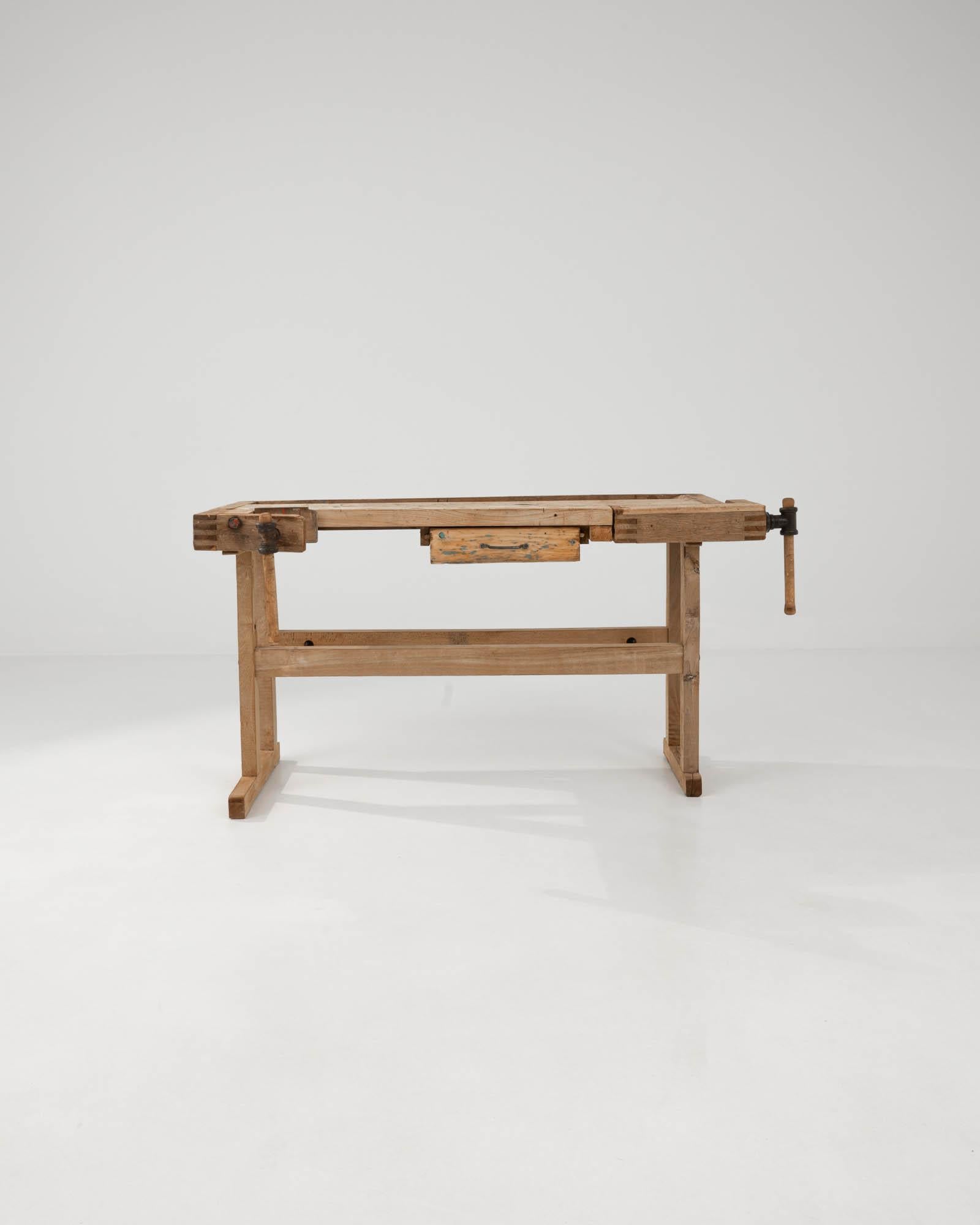 With its workmanlike design and warm natural finish, this vintage wooden table makes a striking Industrial accent. Built in Belgium in the 20th century, this piece would have originally been used as a carpenter’s work bench; the impressive iron