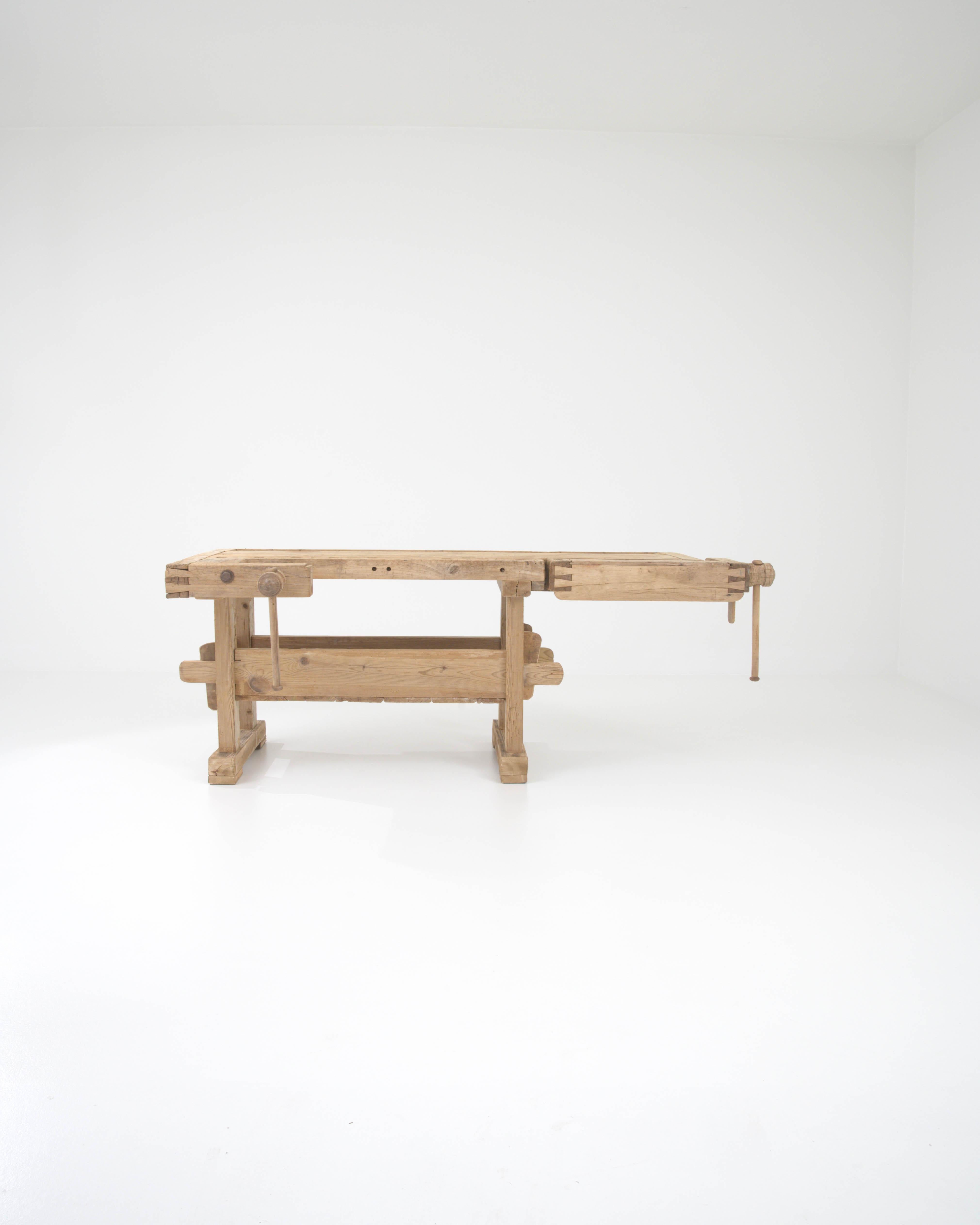 Mit seinem handwerklichen Design und seiner warmen, natürlichen Oberfläche setzt dieser Vintage-Holztisch einen eindrucksvollen industriellen Akzent. Dieses im 20. Jahrhundert in Belgien gebaute Stück wurde ursprünglich als Werkbank eines Schreiners