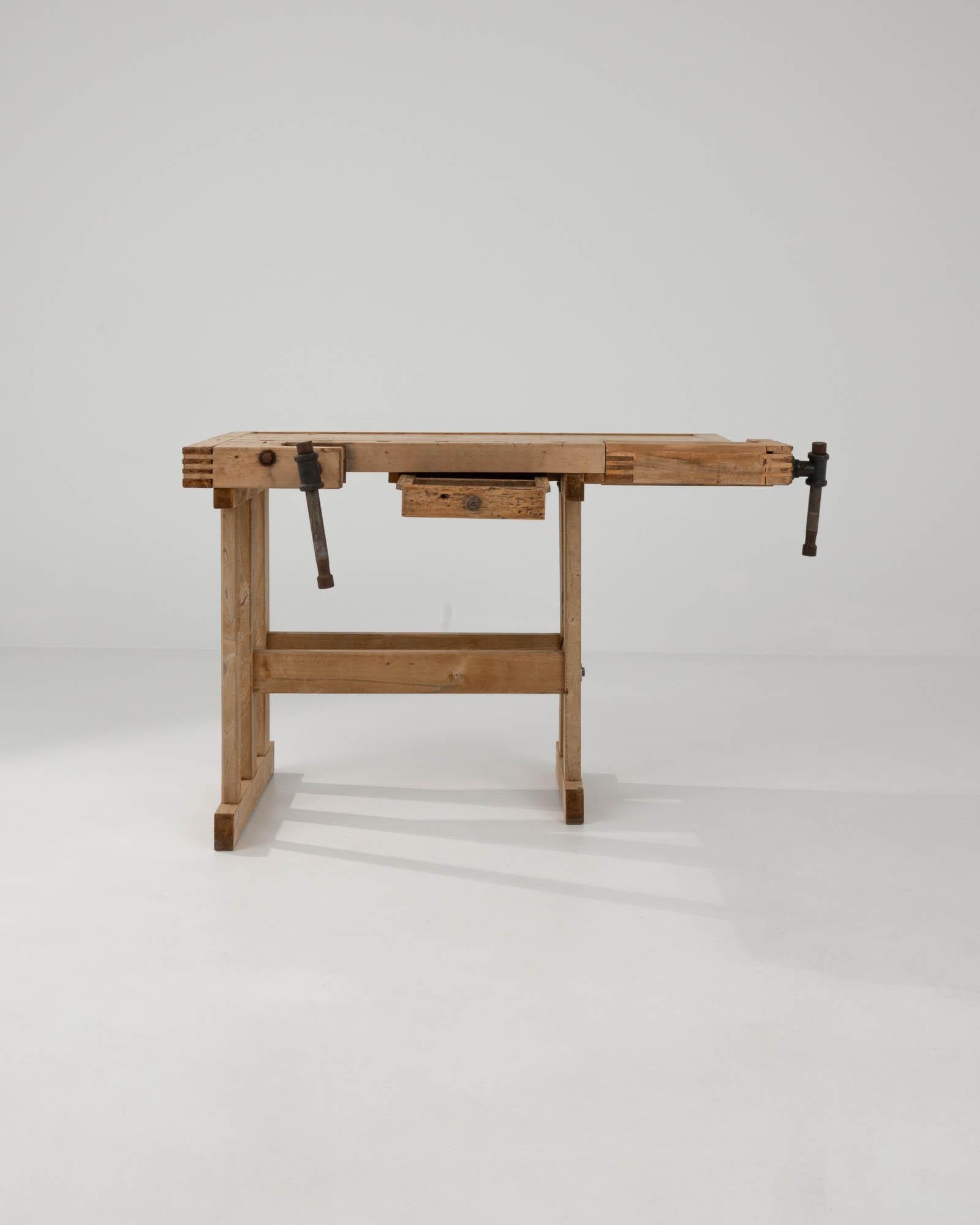 Mit seinem handwerklichen Design und seiner warmen, natürlichen Oberfläche setzt dieser Vintage-Holztisch einen eindrucksvollen industriellen Akzent. Das im 20. Jahrhundert in Belgien gebaute Stück diente ursprünglich als Werkbank eines Schreiners;