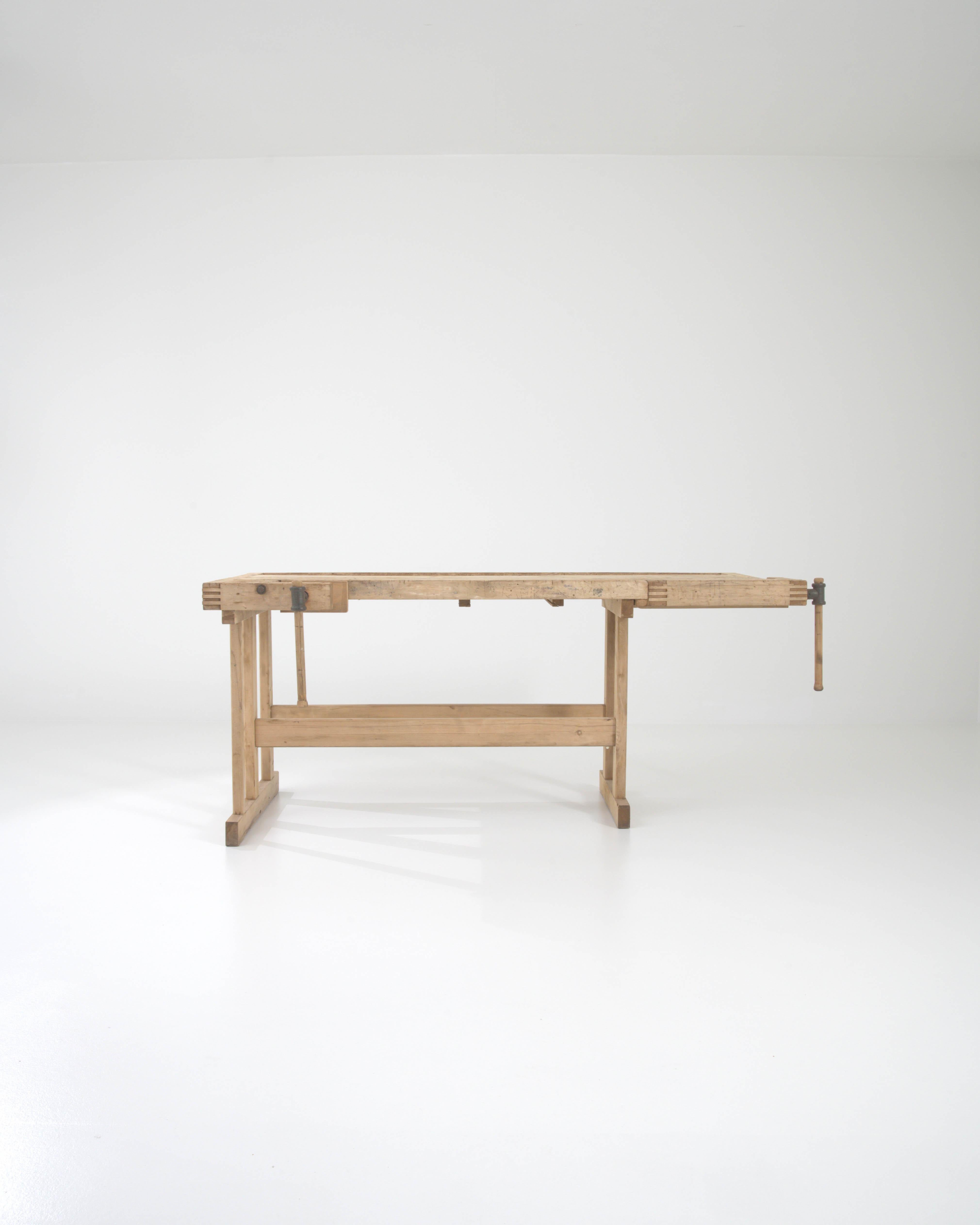 Mit seinem handwerklichen Design und seiner warmen, natürlichen Oberfläche setzt dieser Vintage-Holztisch einen eindrucksvollen industriellen Akzent. Das im 20. Jahrhundert in Belgien gebaute Stück diente ursprünglich als Werkbank eines Schreiners;