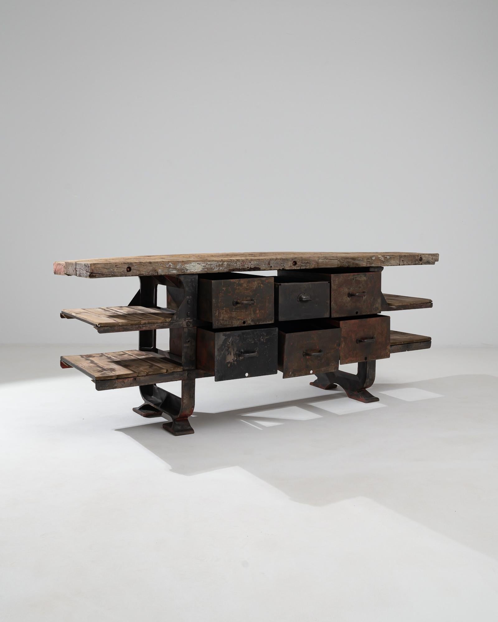 This vintage Industrial table combines robust practicality with a nostalgic, textural appeal. Made in Belgium in the 20th century, this piece would have originally been a fixture in a workshop or a factory —solid and immovable, the large rivets of