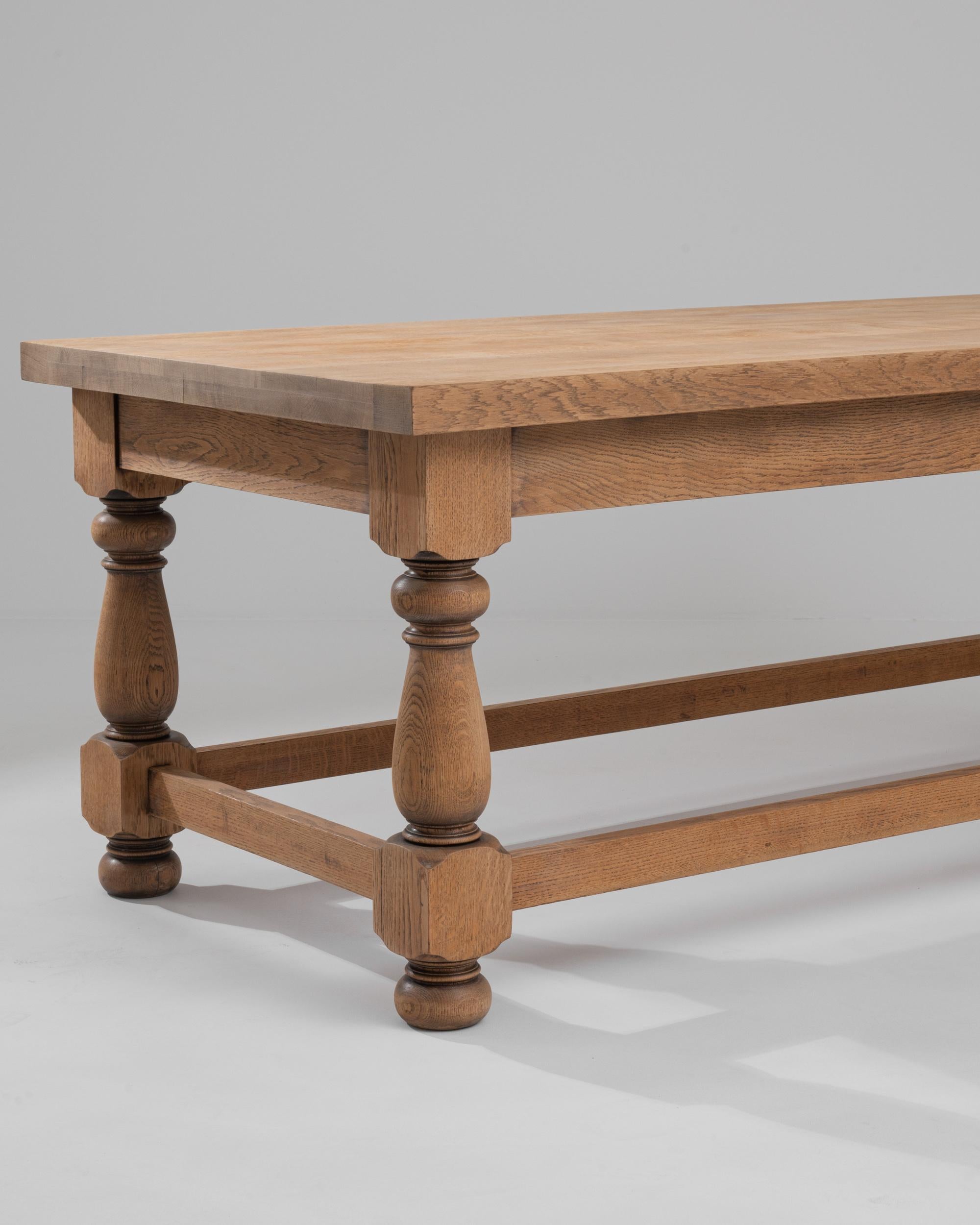 Elevate your dining experience with the 20th Century Belgian Wooden Dining Table, a vintage masterpiece that exudes timeless French charm. Crafted from wood, this dining table showcases a rectangular-shaped top supported by four beautifully turned