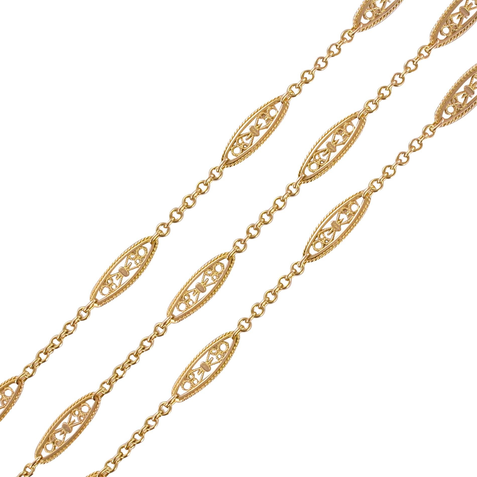 Necklace in 18 karat rose gold, eagle's head hallmark.
A delightful antique long necklace, it is made up of a jaseron chain punctuated with shuttle pattern traversed by filigrees, and each bordered by a small gold cord. The clasp is a
