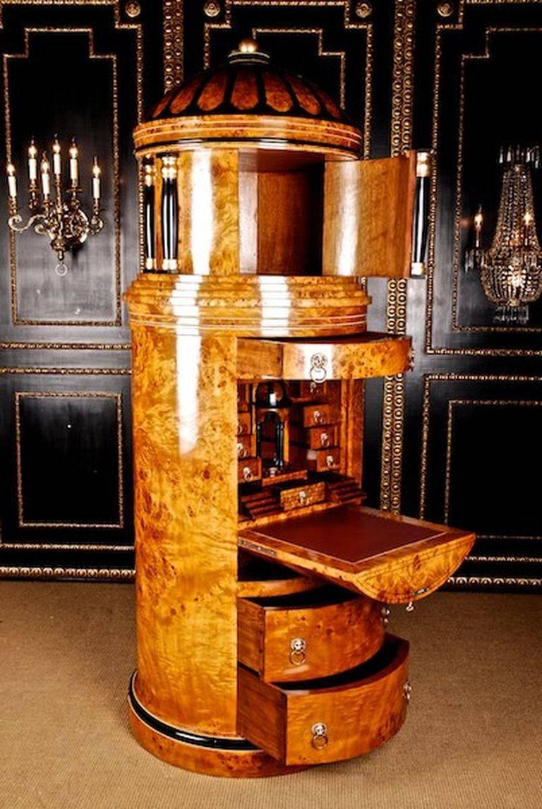 Monumental secretaire in column-form in Biedermeier style.
Maple root on solid pinewood, partially ebonized. Column formed bowed body on round prominent bottom plate. In the structured front, three drawers of different size. Bowed writing- tablets,