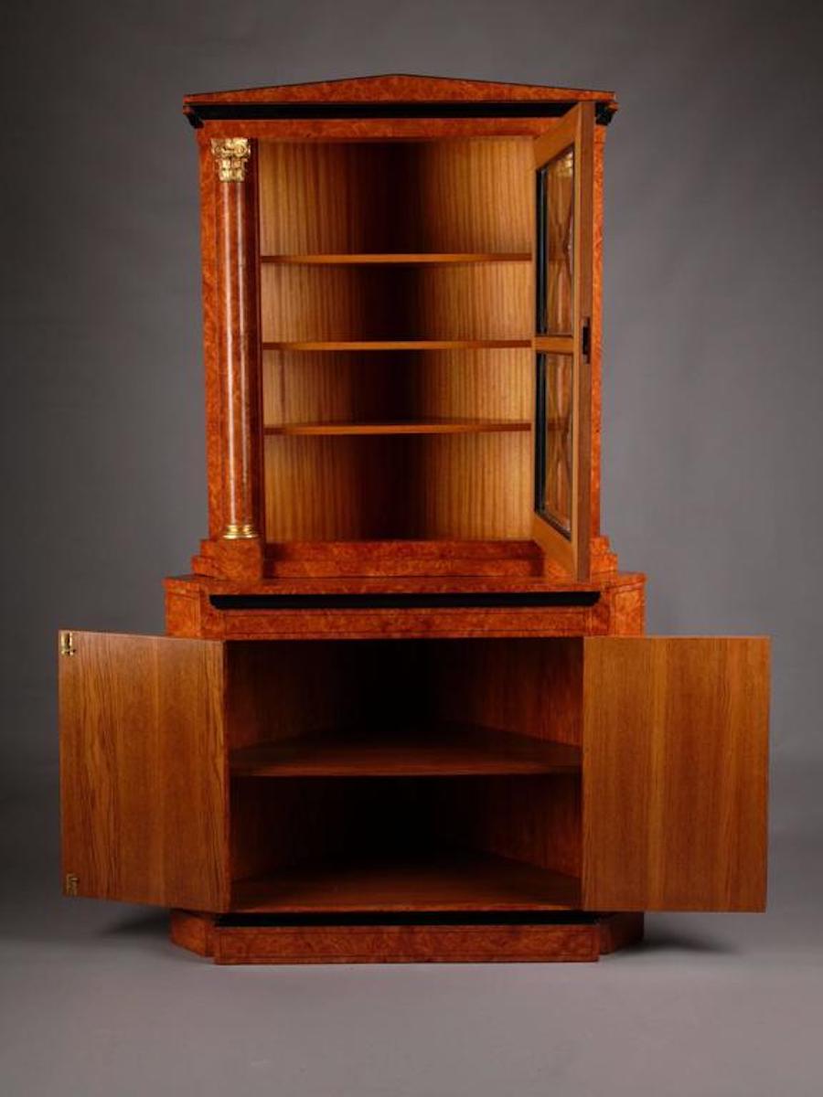Elegante credenza angolare in stile Biedermeier.
Impiallacciatura di radice di acero a occhio di uccello su legno di pino massiccio. Parzialmente ebanizzato. Corpo a due cassetti su piedistallo sporgente, ripiani interni. Piatto da portata stretto e