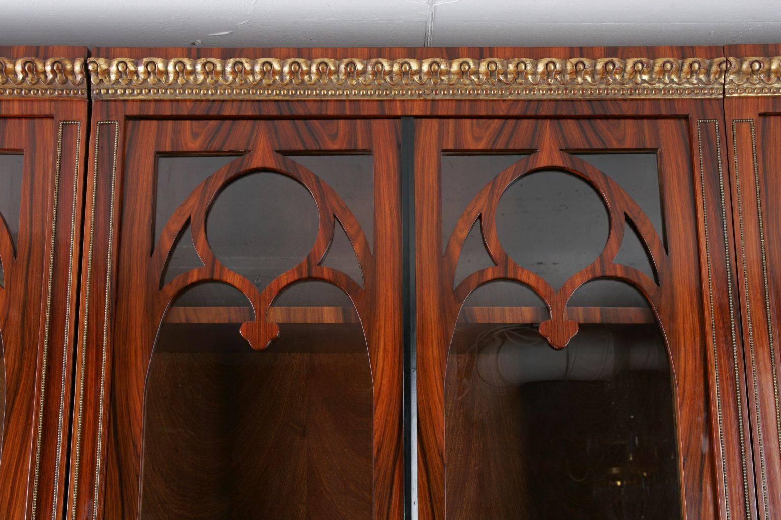 Highly significant library cupboard in Biedermeier style.
 Veneer on solid pinewood. Architectural structured front crested with neo-Gothic elements. Over straight pedestal highly rectangular corpus. Profile cornice carved and gilded.

(O-Sam-15).