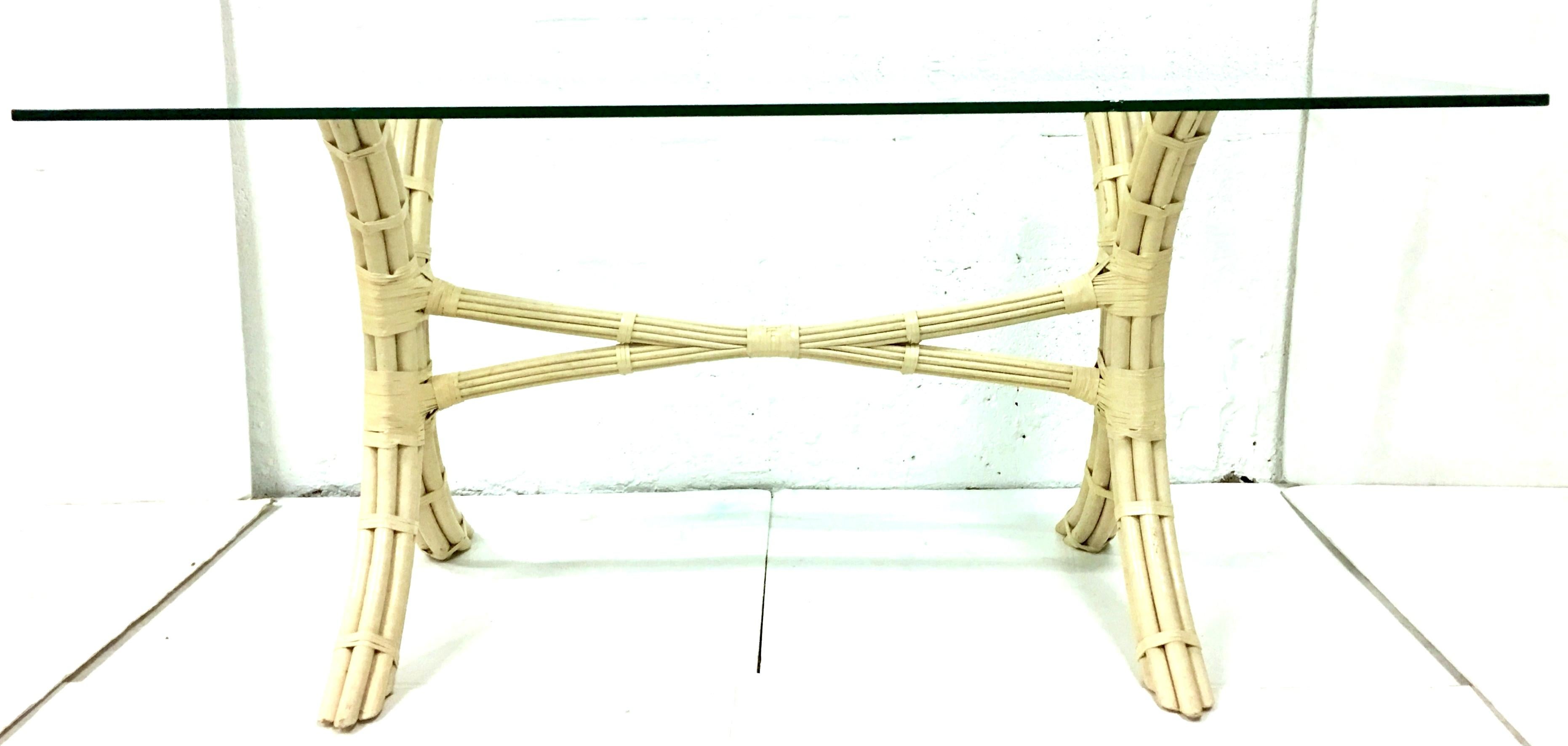 20th Century Bielecky Brothers style rattan and glass top dining table. This large and rectangular rattan reed with raw hide leather wrap detail table is executed in the original and rare manufacturer paint of a neutral bone tone color. The very