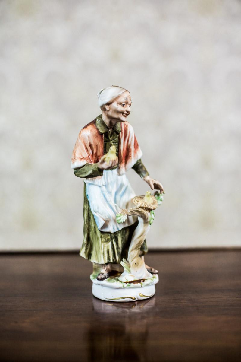 We present you this small figurine made of bisque, a type of porcelain without a glaze, with the depiction of an older womanwith birds.

The item is modern.

Presented figurine is undamaged, in perfect condition.