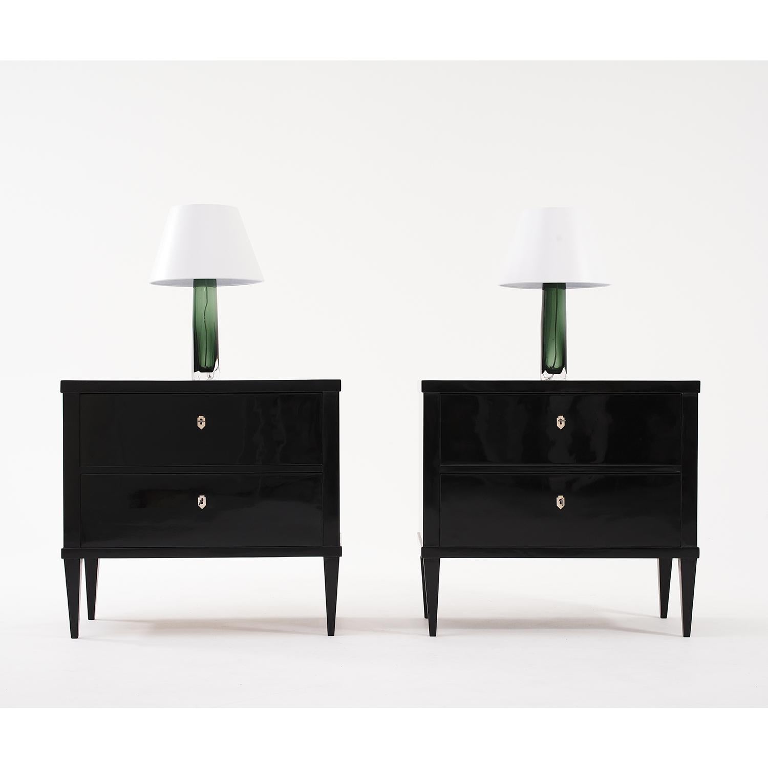 A black, vintage French Art Deco pair of chests made of hand crafted ebonized wood, in good condition. The Parisian commodes are composed with two large drawers, consisting with its original metal hardware and keys. The cupboards are standing on