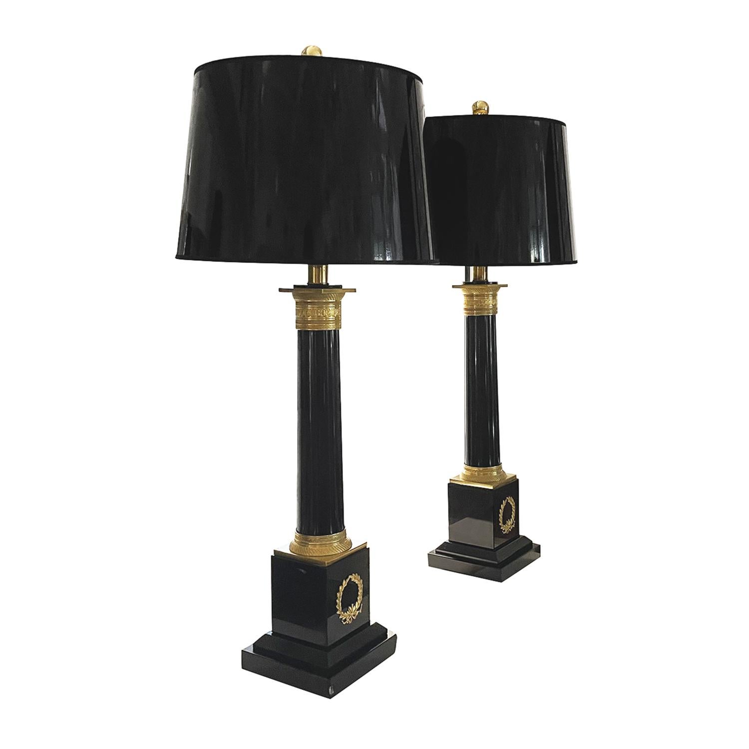 A black, vintage French pair of large table lamps made of hand crafted marble with a new round shade, in good condition. They are composed with its original switch, particularized by gilded bronze décor, featuring a one light socket. The Parisian
