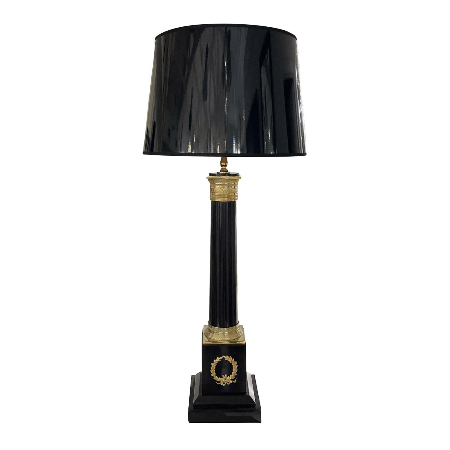 A black, vintage French pair of large table lamps made of hand crafted marble with a new round shade, in good condition. They are composed with its original switch, particularized by gilded bronze décor, featuring a one light socket. The Parisian
