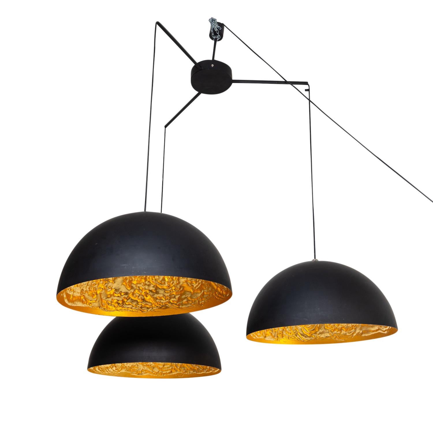 A black-gold, vintage late Mid-Century Modern Italian ceiling light, lamp made of handcrafted polished metal, designed and produced by Catellani & Smith in good condition. The chandelier, pendant is consisting three round hemispherical shades with