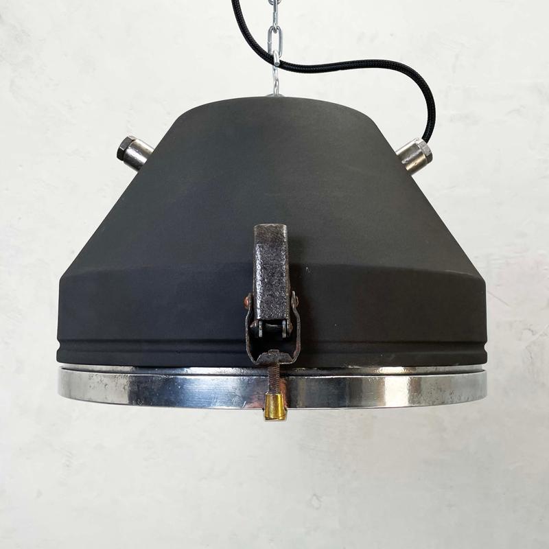 A vintage industrial steel ceiling light by VEB with black iron powder coat finish. These ceiling lights date back to the 1970s where they were used as cargo bay lighting. The glass rim has three quick release catches which open to reveal the lamp.